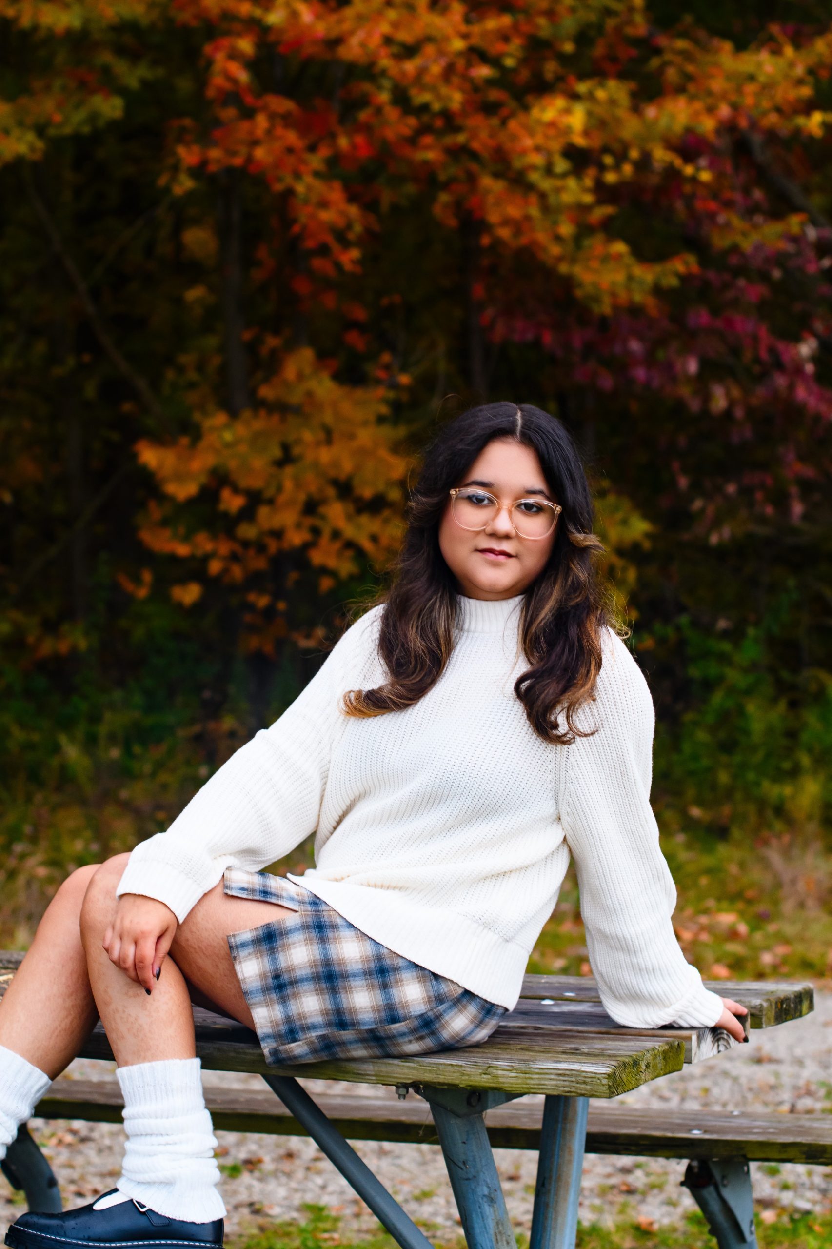 Carmen seated on a bench with guitar during Allen Park 2025 senior photography session
