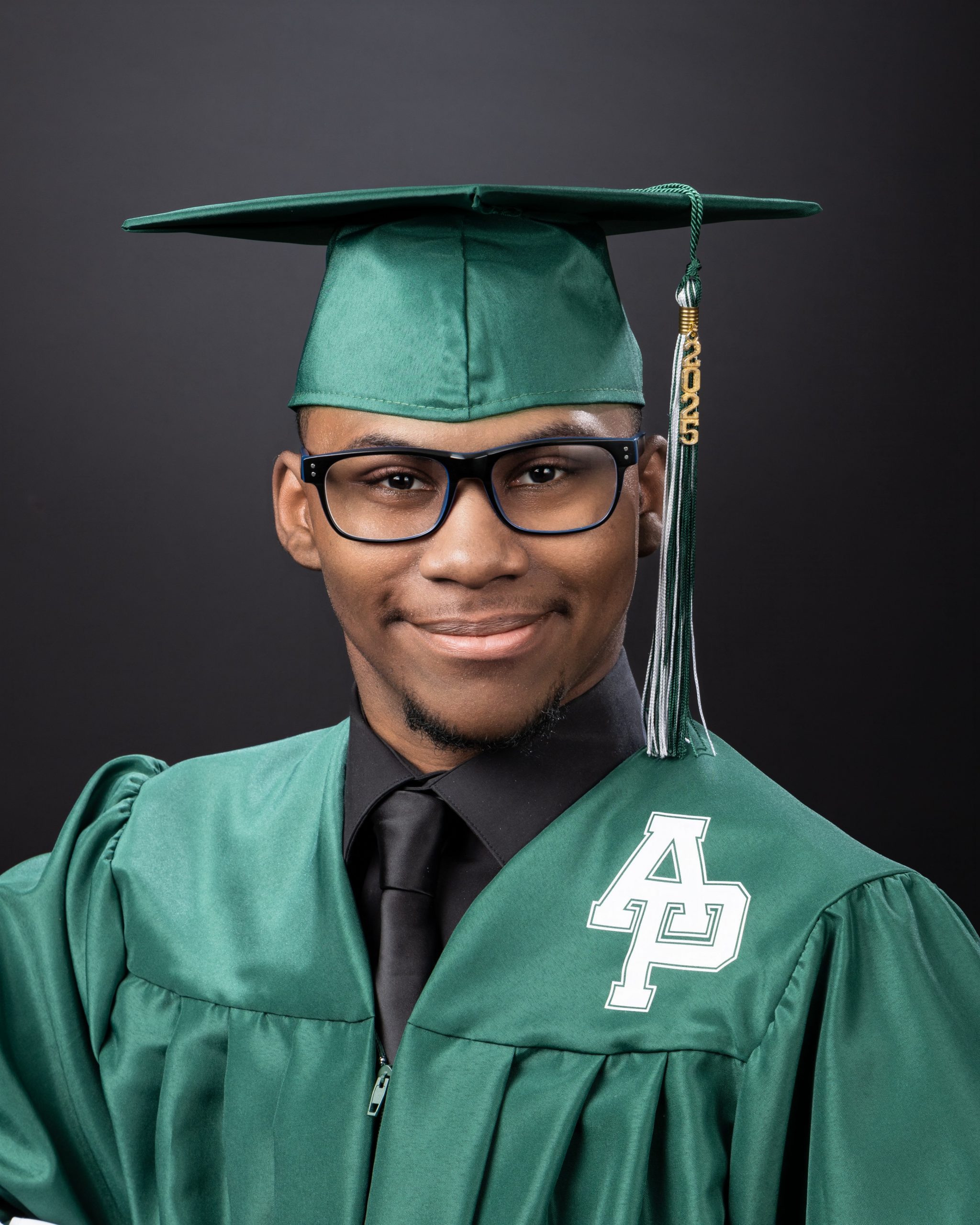 Green graduation gown with '4P' emblem and 2025 tassel in studio session