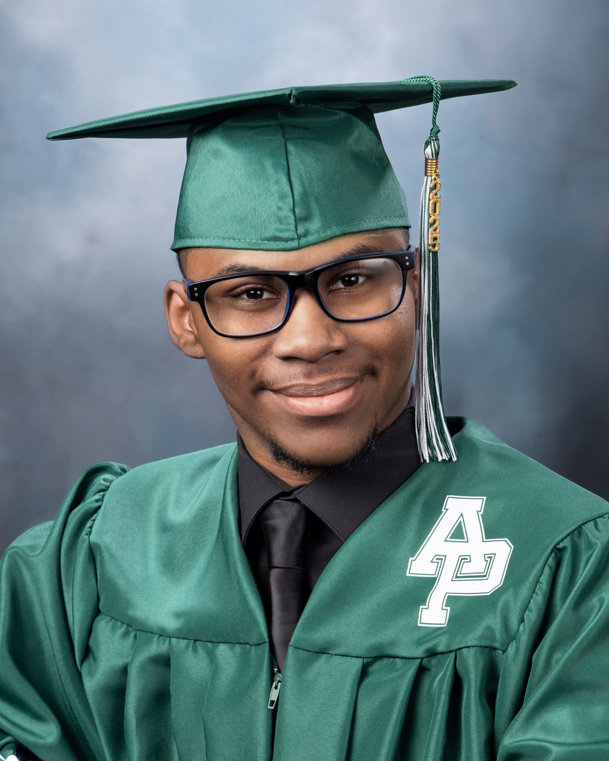 Green graduation gown with 'AP' emblem and 2025 tassel in studio session
