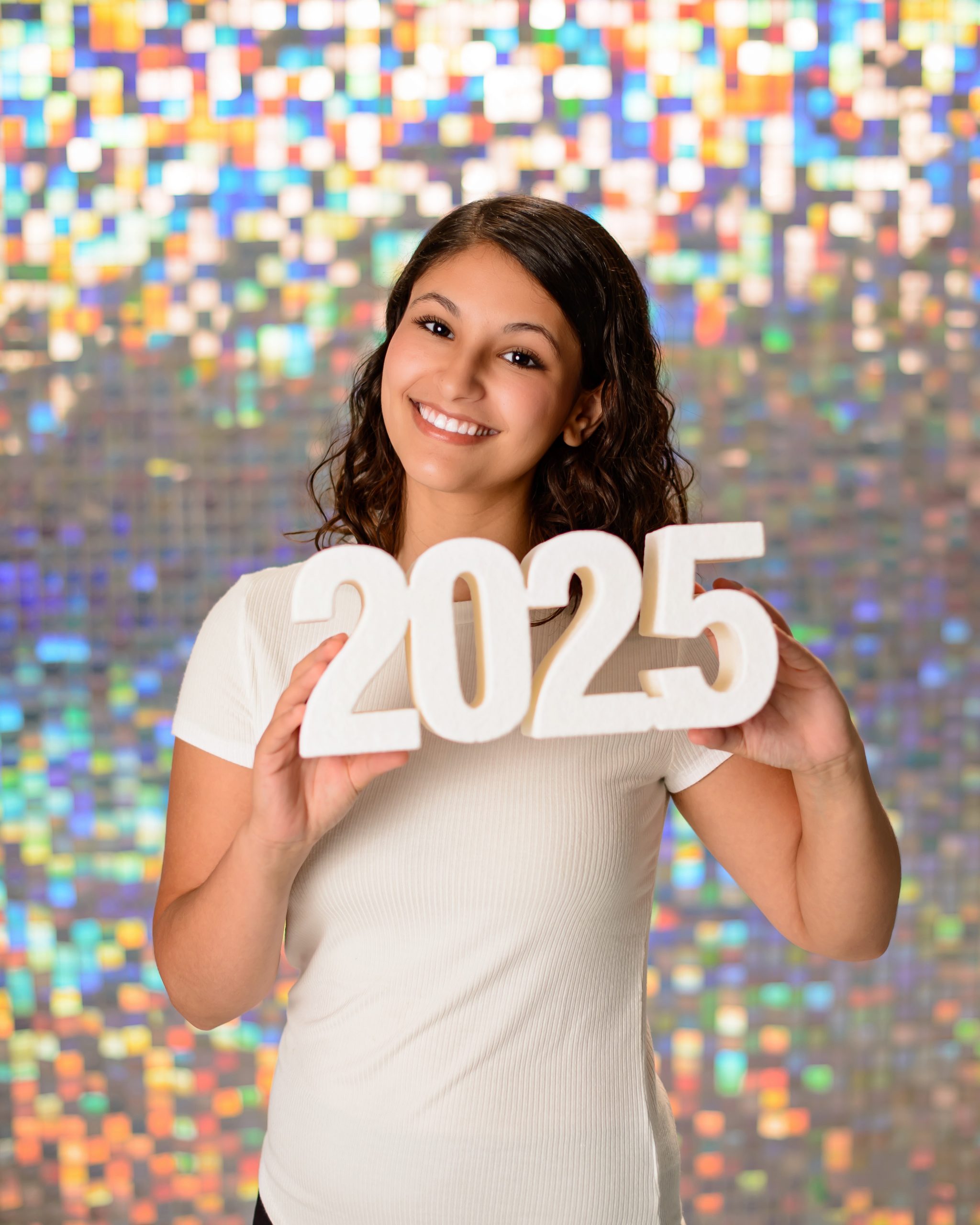 Senior holding 2025 year markers for graduation photo session