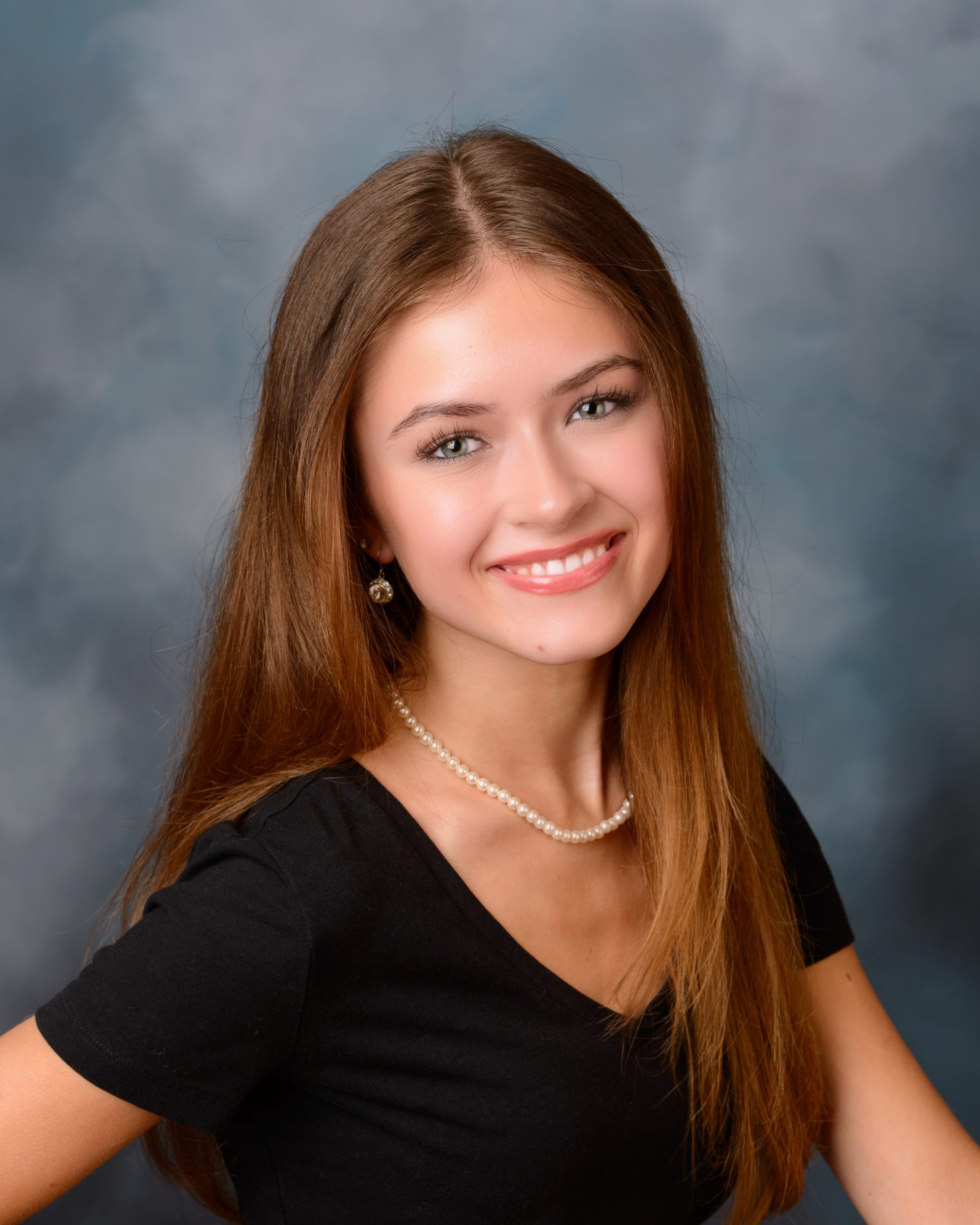 Green cap and gown portrait with mansion studio backdrop