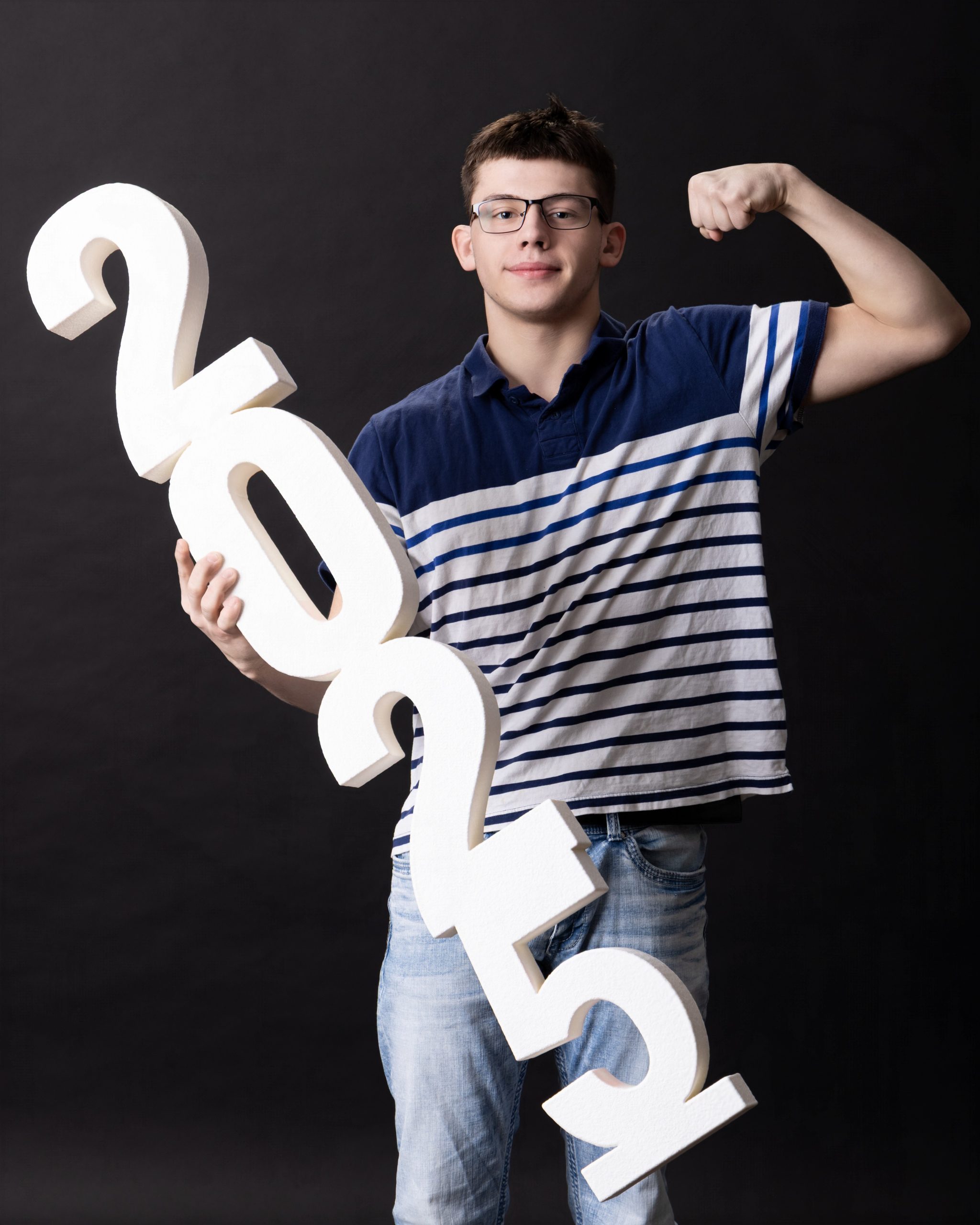 senior student posing with question mark prop during studio session