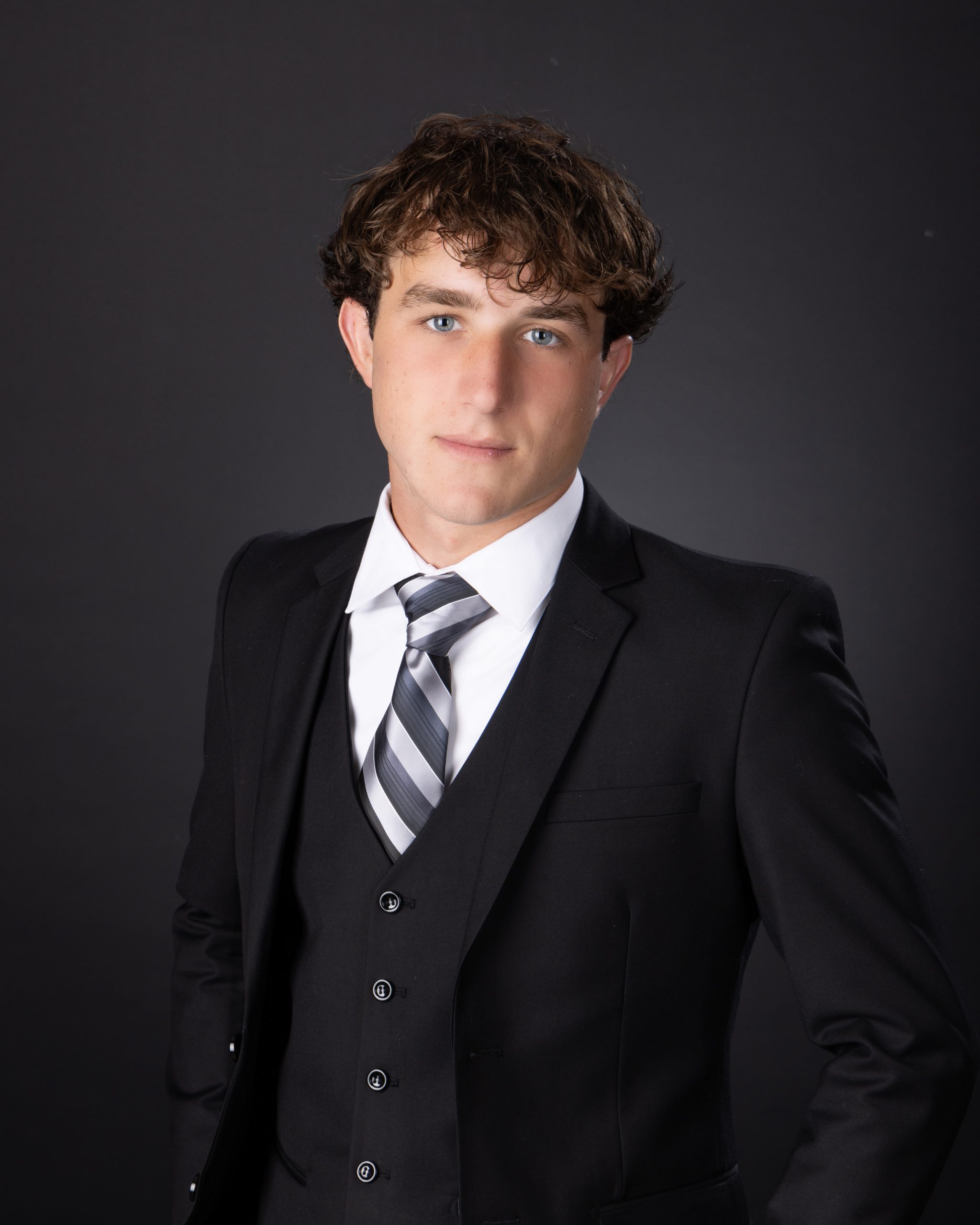 Allen Park Senior Cody 2025 formal portrait in black suit and striped tie