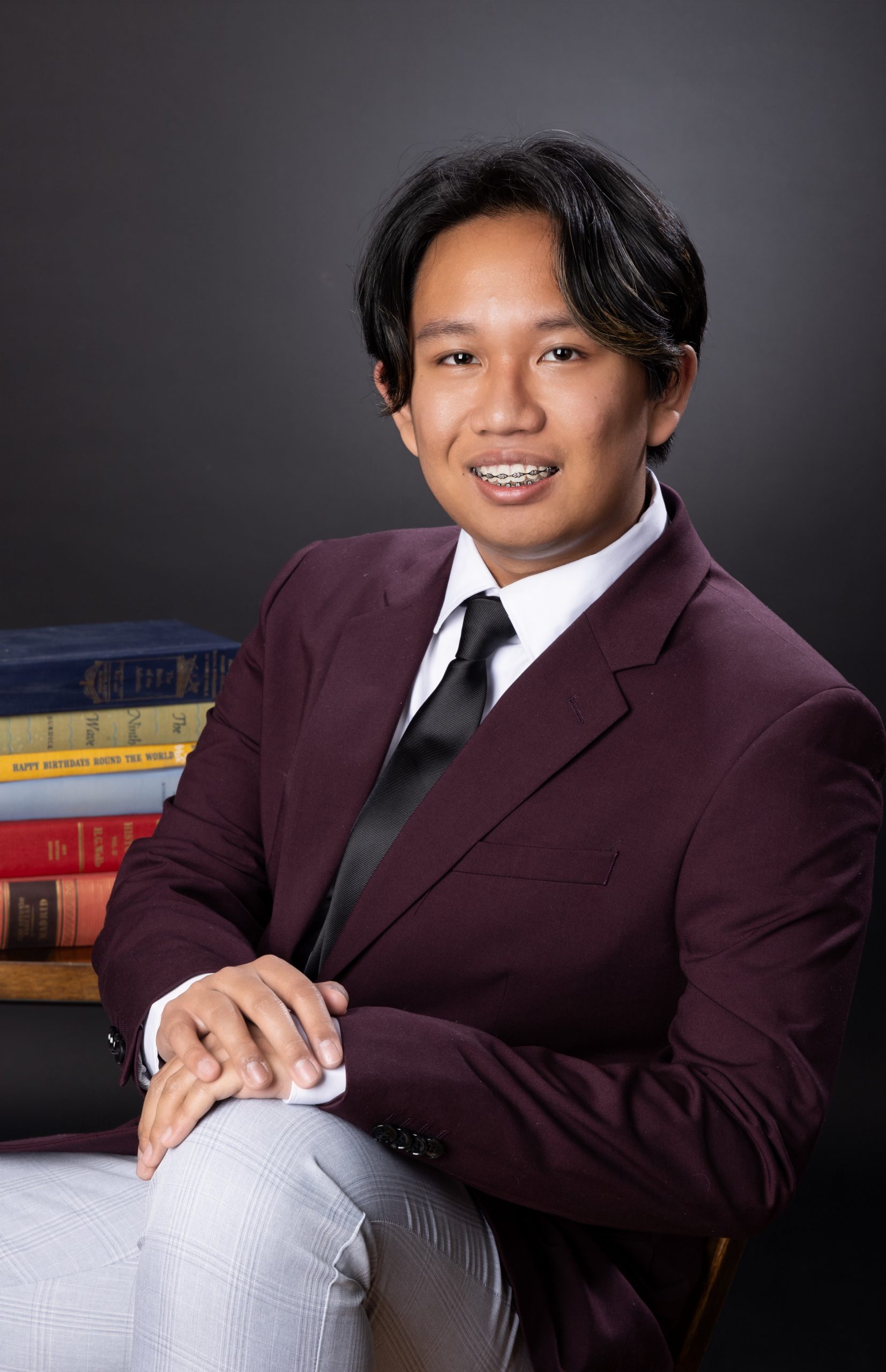 Eric seated with book stack in Downriver photography studio session