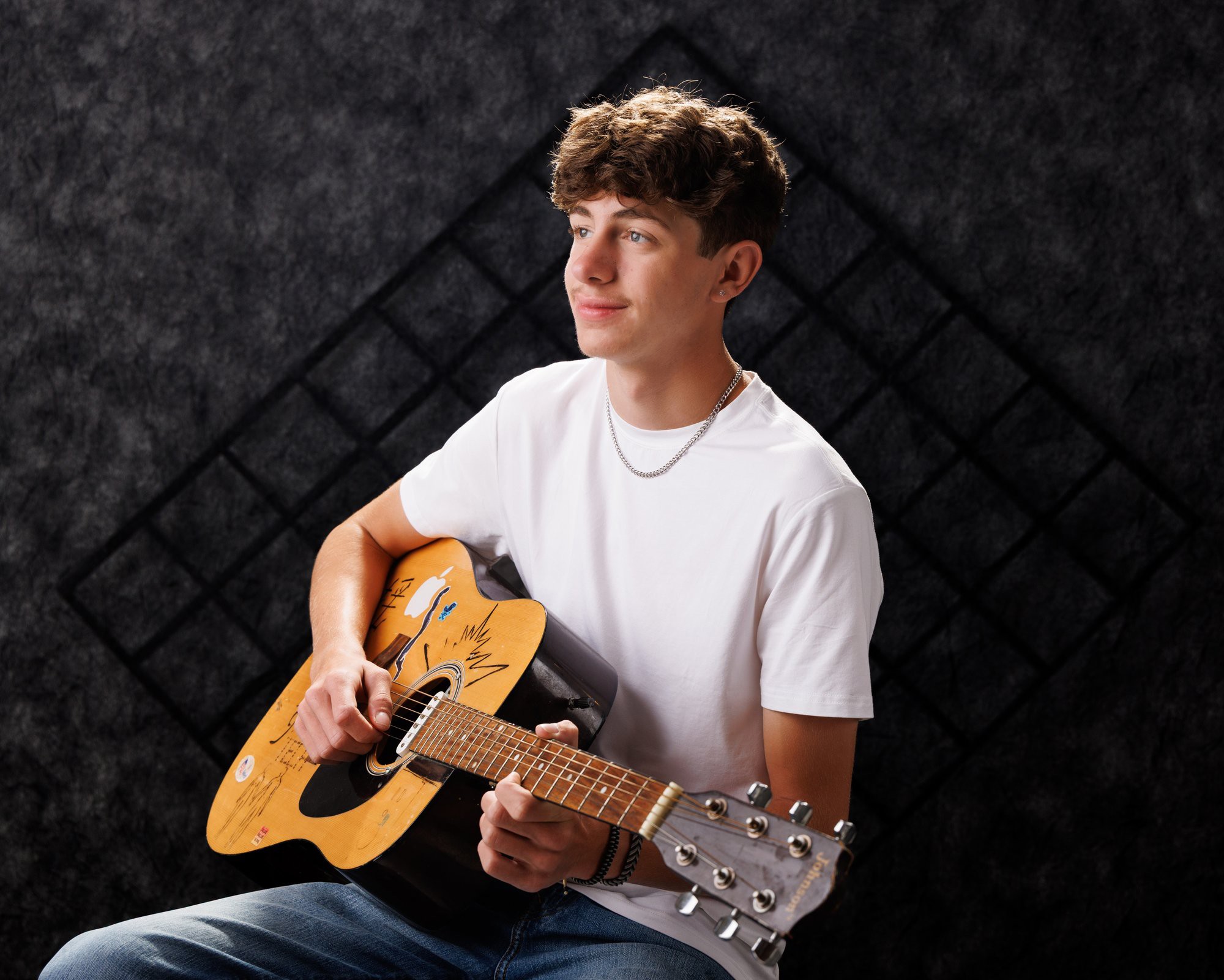 Gavin Allen Park senior holding an acoustic guitar with handwritten notes