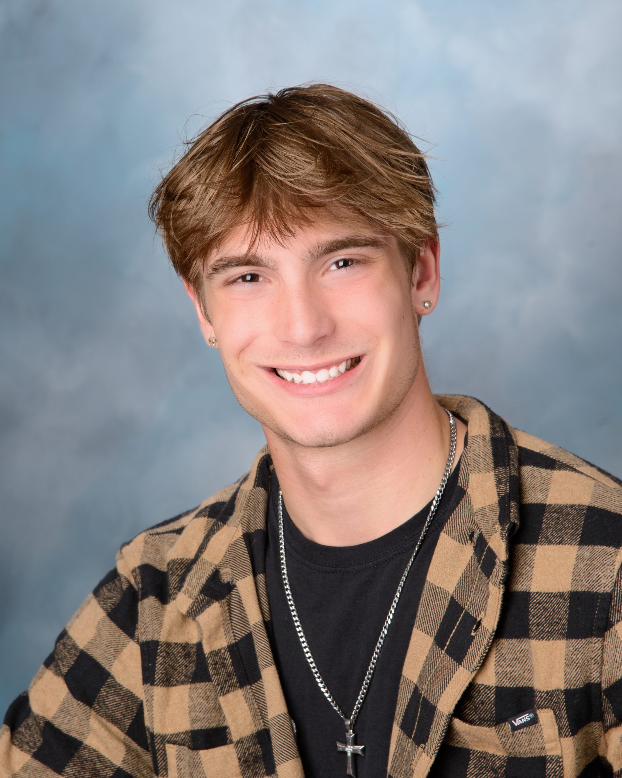 casual plaid shirt and black tee senior portrait with blue backdrop