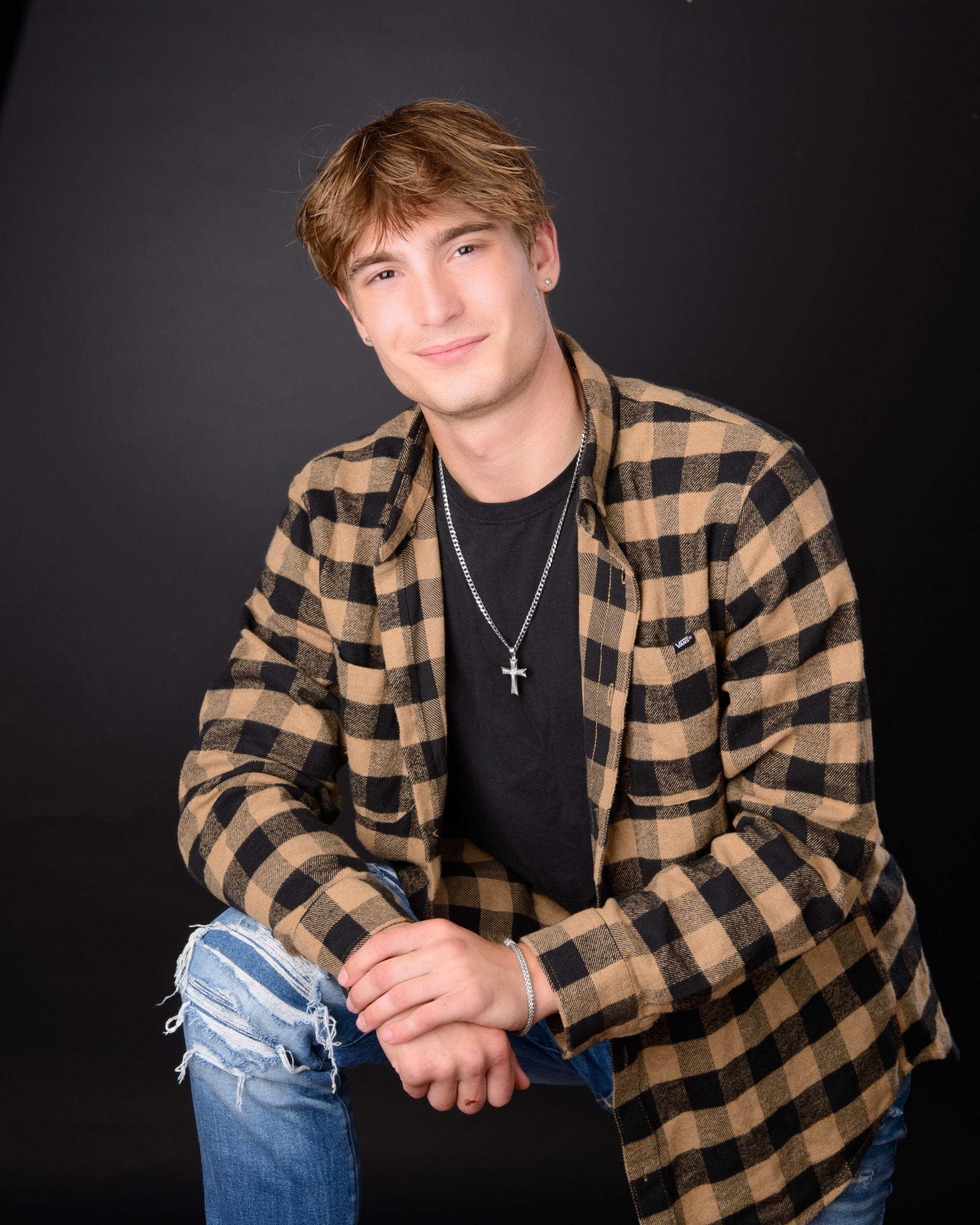 dark backdrop senior photography portrait with relaxed pose