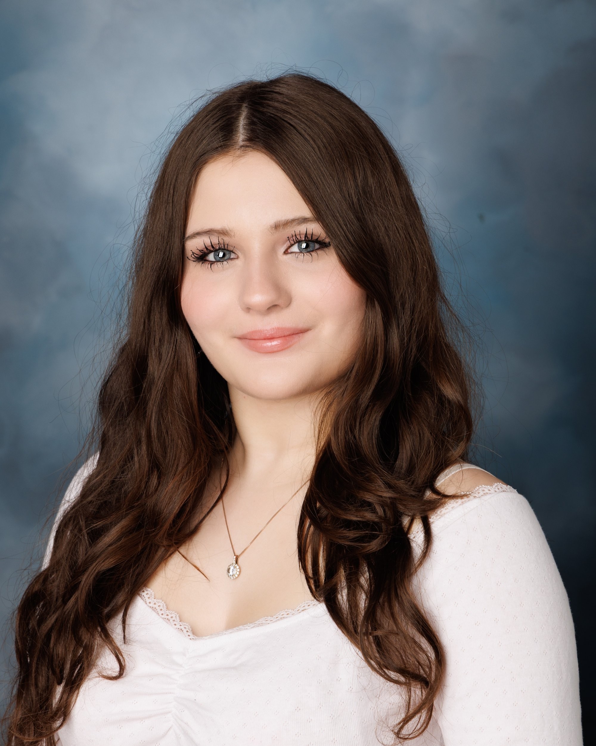 Kayleigh's studio senior portrait with soft lighting, ruched white top, and single pendant necklace