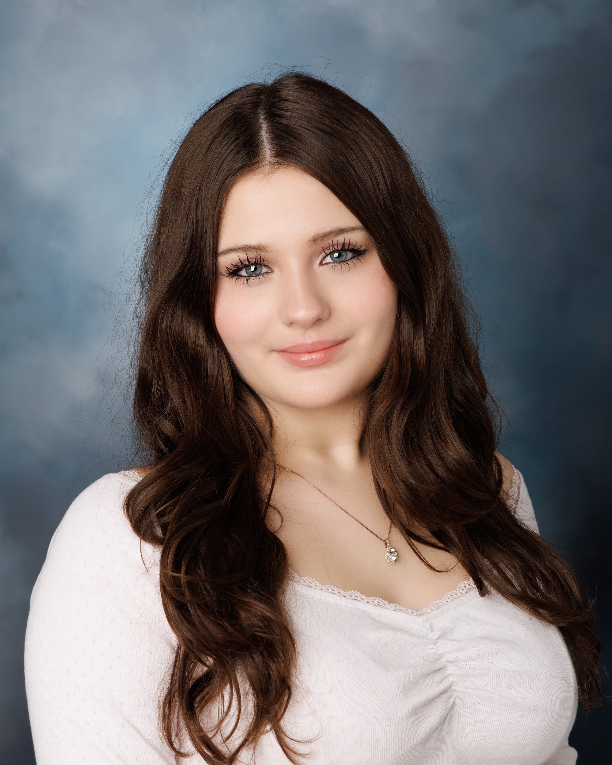 Kayleigh's studio senior portrait with soft lighting, ruched white top, and single pendant necklace