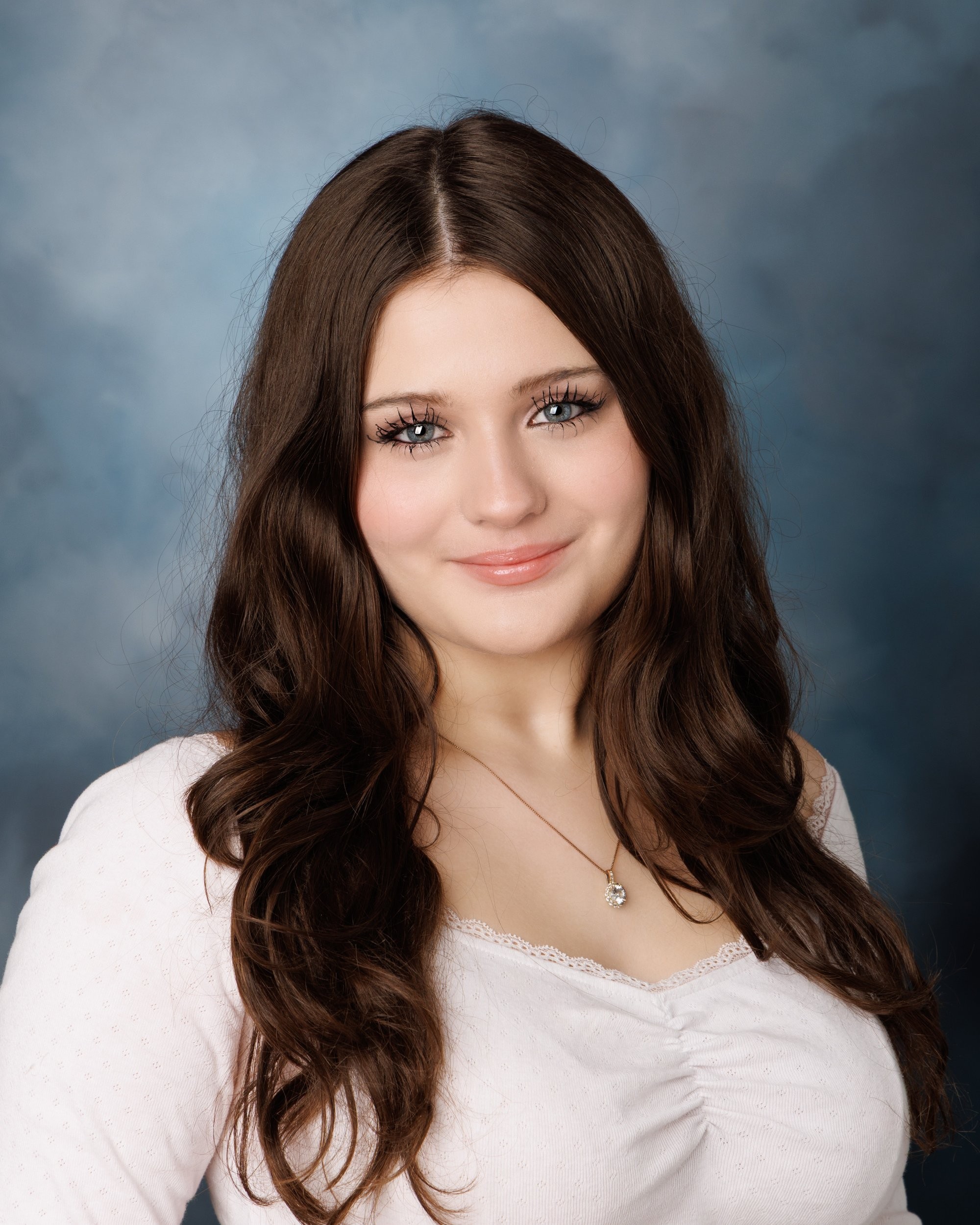 Kayleigh's studio senior portrait with soft lighting, ruched white top, and single pendant necklace