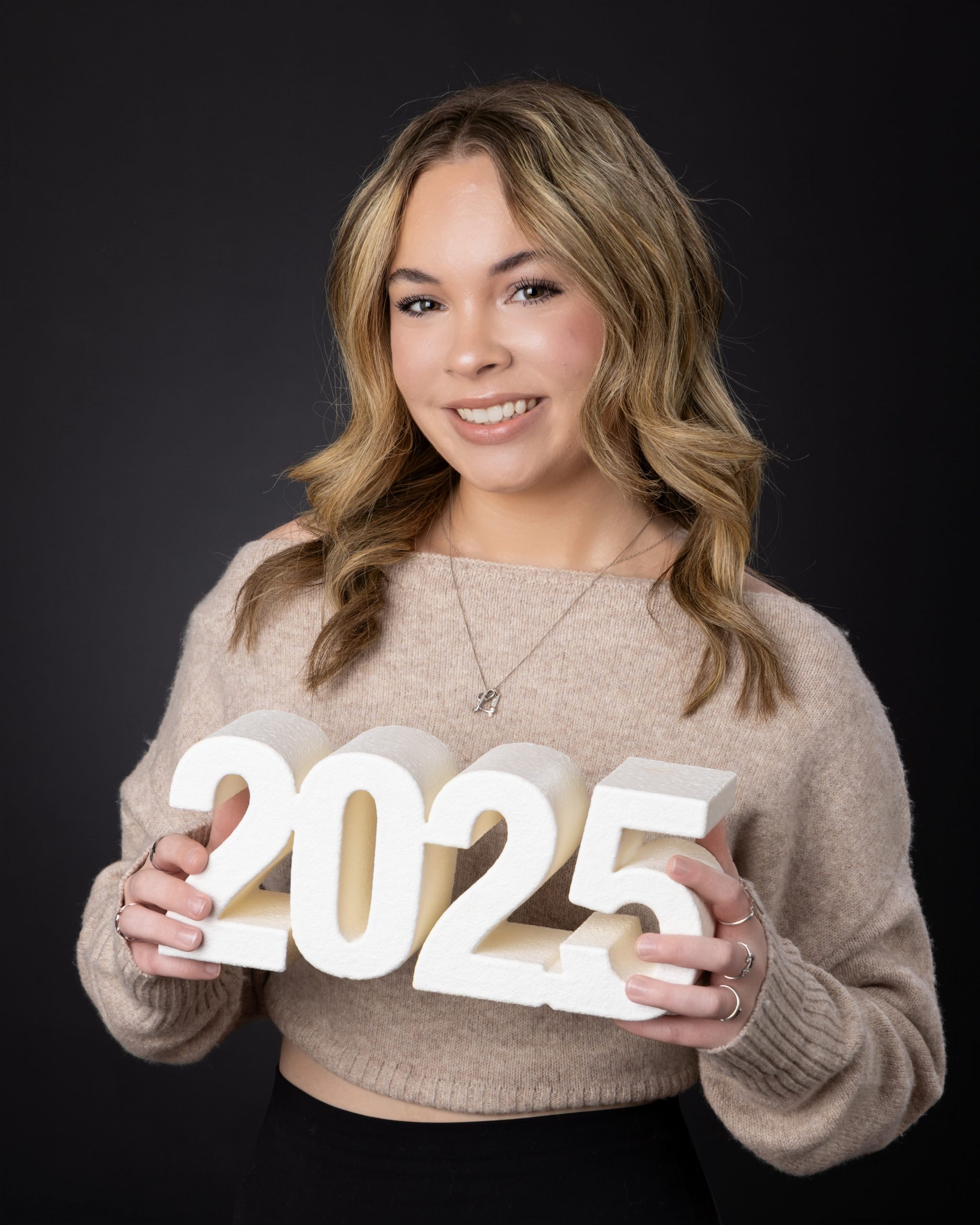 Lexi holding 2025 numerals for her Downriver studio session at Studio ONE