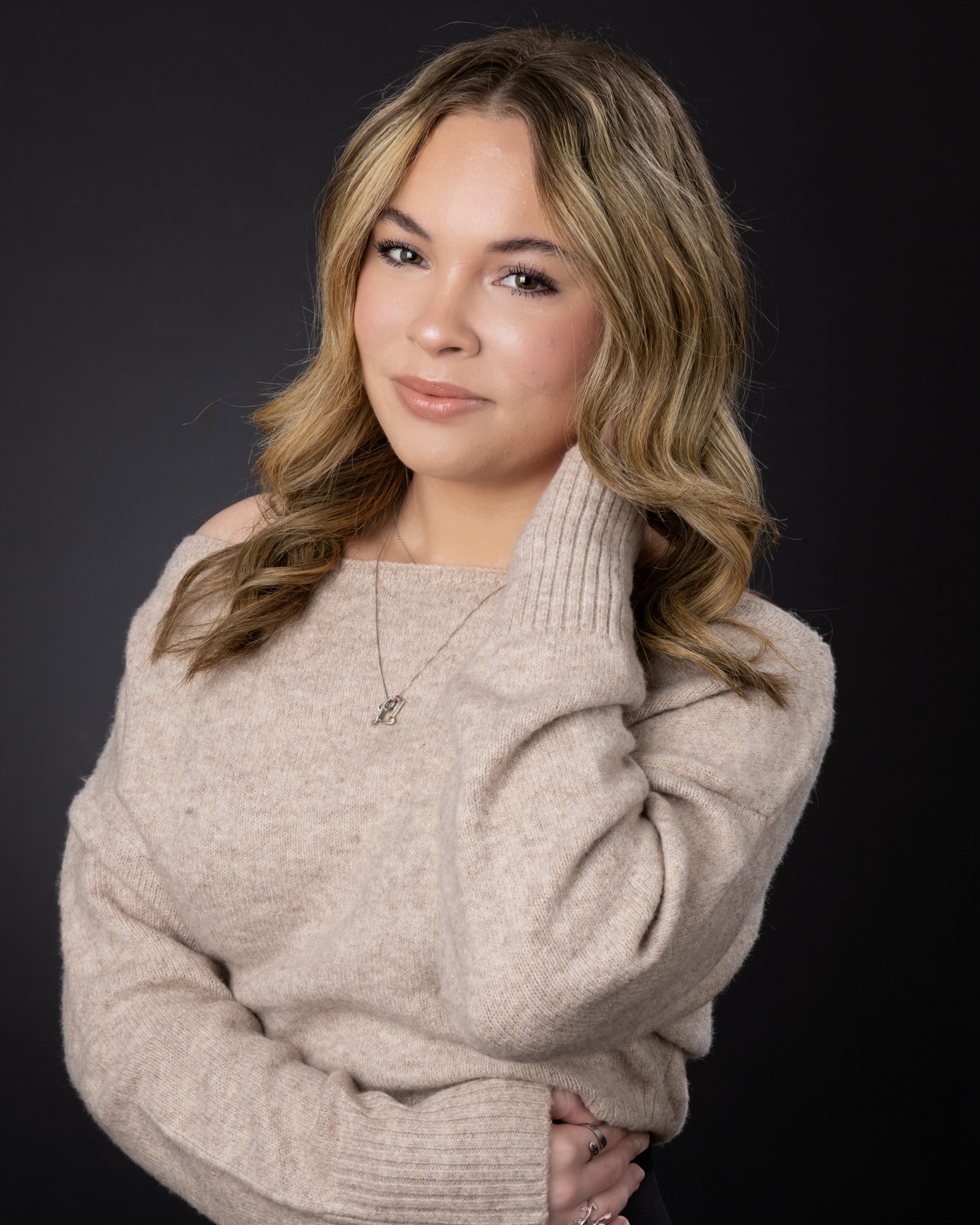 Relaxed pose of Lexi in a beige sweater during Wyandotte photo studio's senior photography session