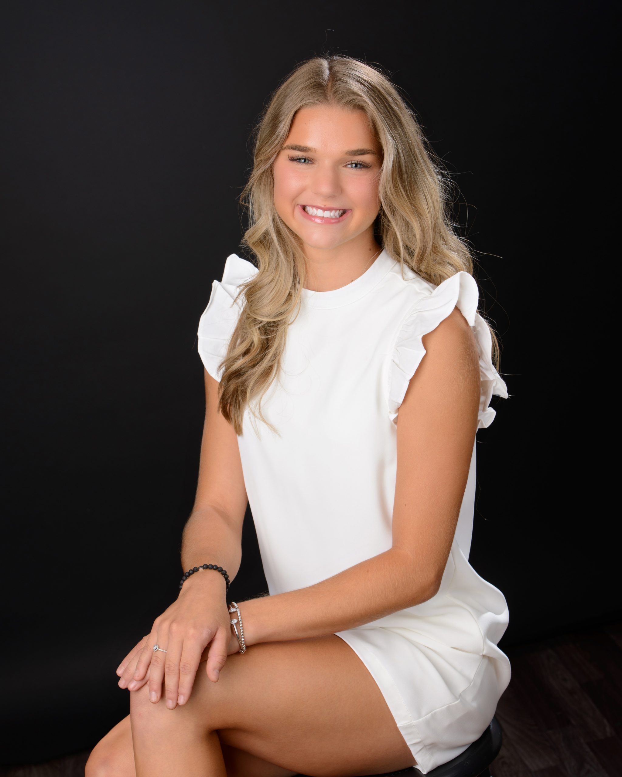 Morgan posing confidently in front of colorful mosaic wall during Downriver senior photo shoot
