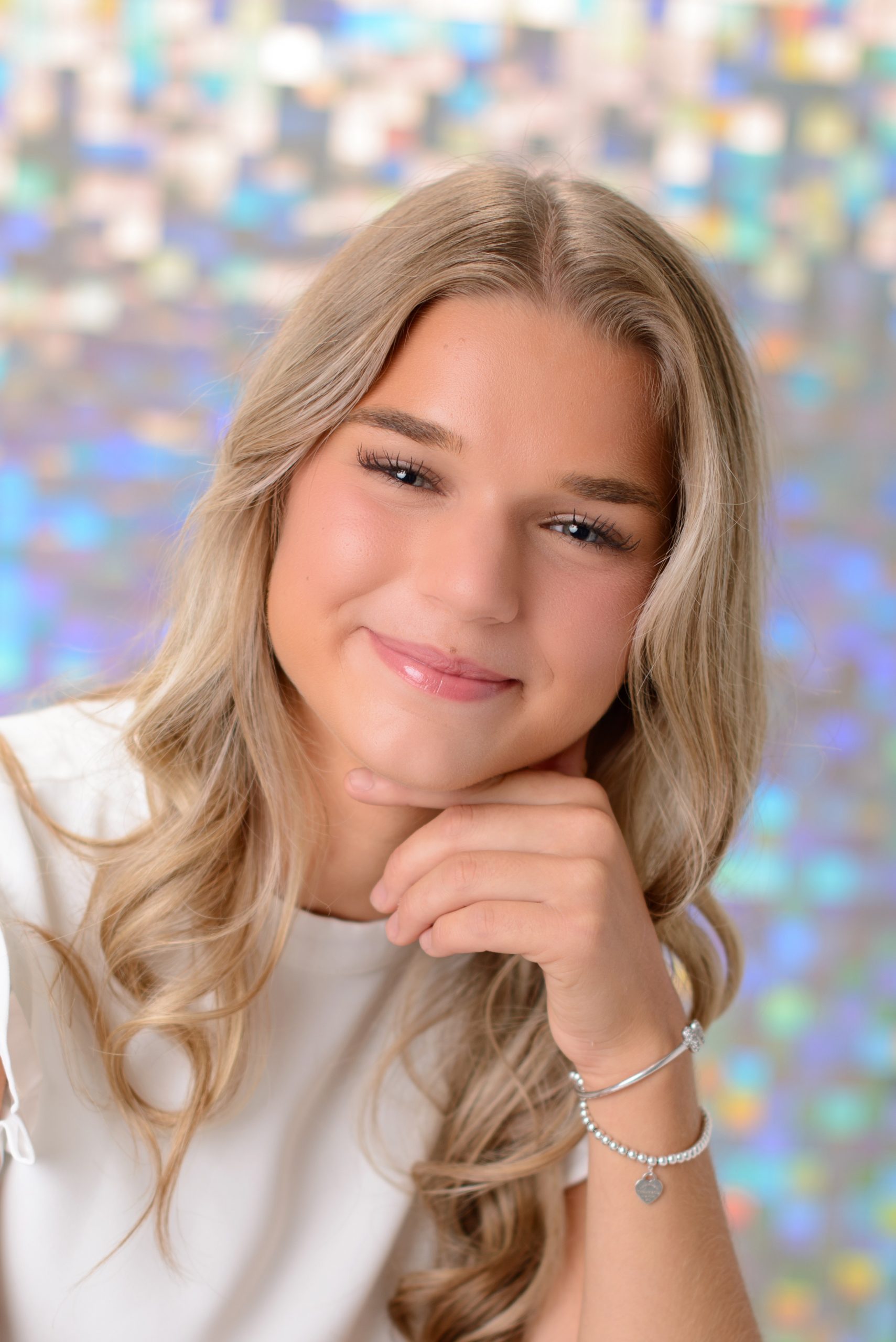 Morgan posing confidently in front of colorful mosaic wall during Downriver senior photo shoot