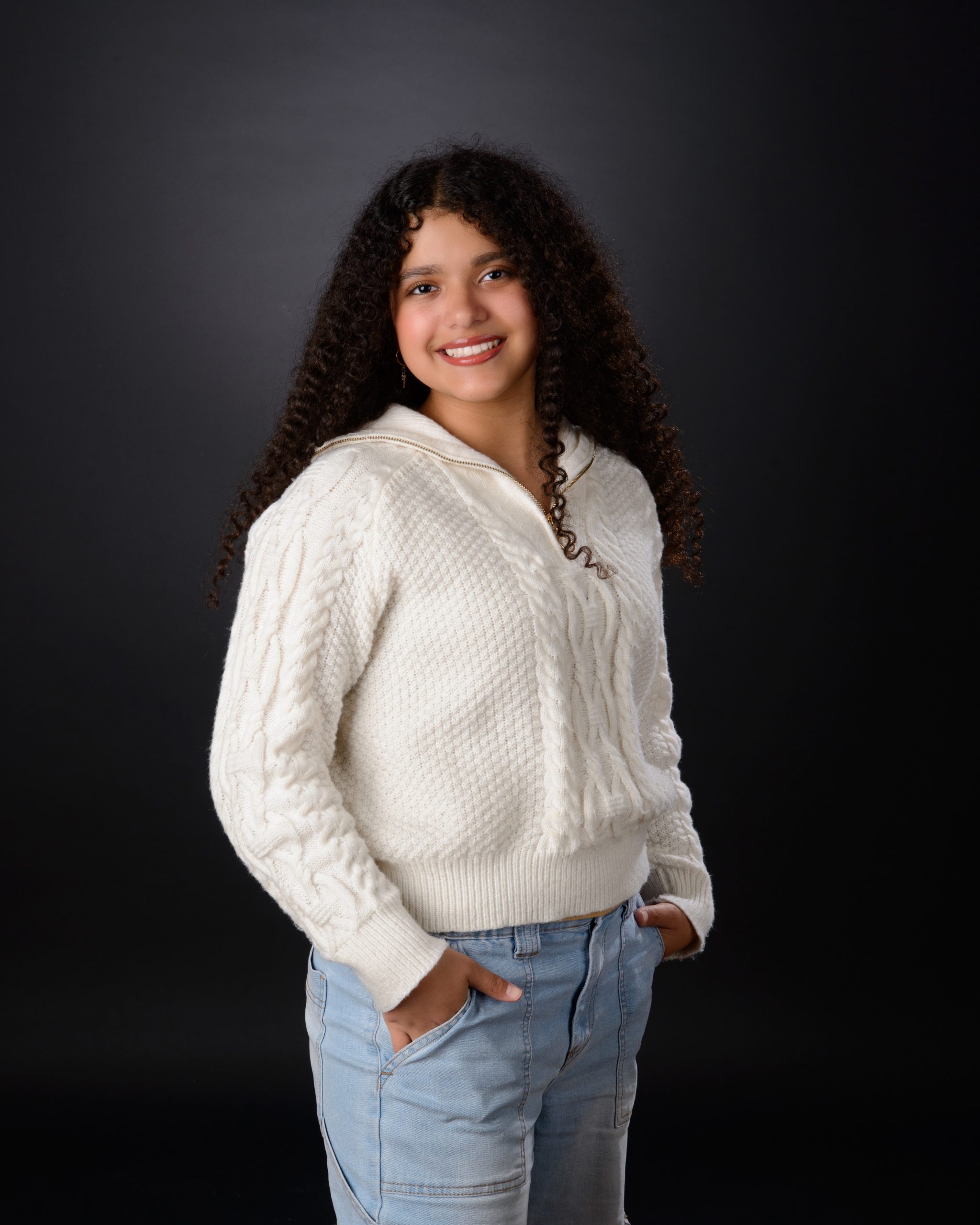 Senior student holds 'Class of 2025' chalkboard sign for Allen Park school photography session