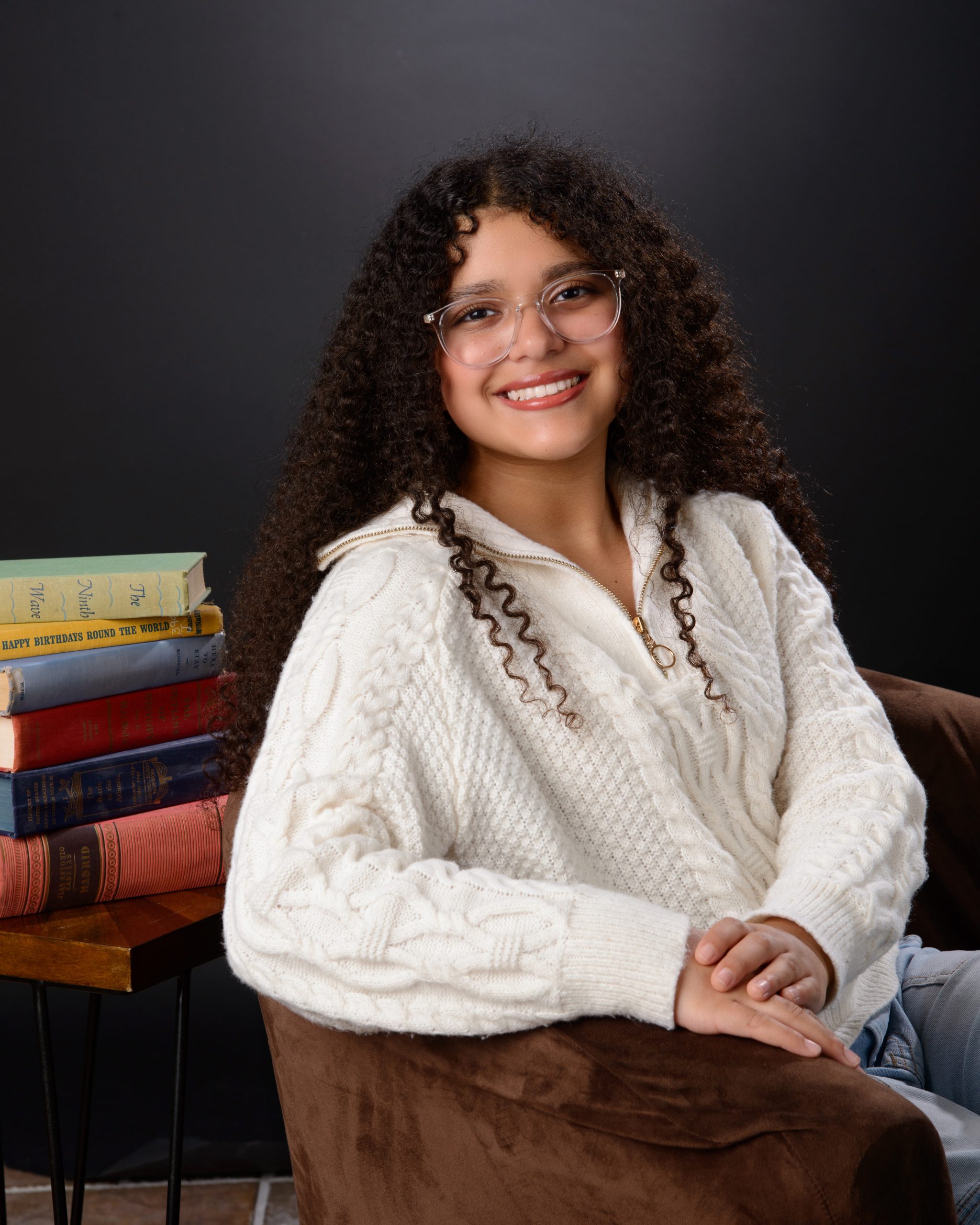 Senior student holds 'Class of 2025' chalkboard sign for Allen Park school photography session