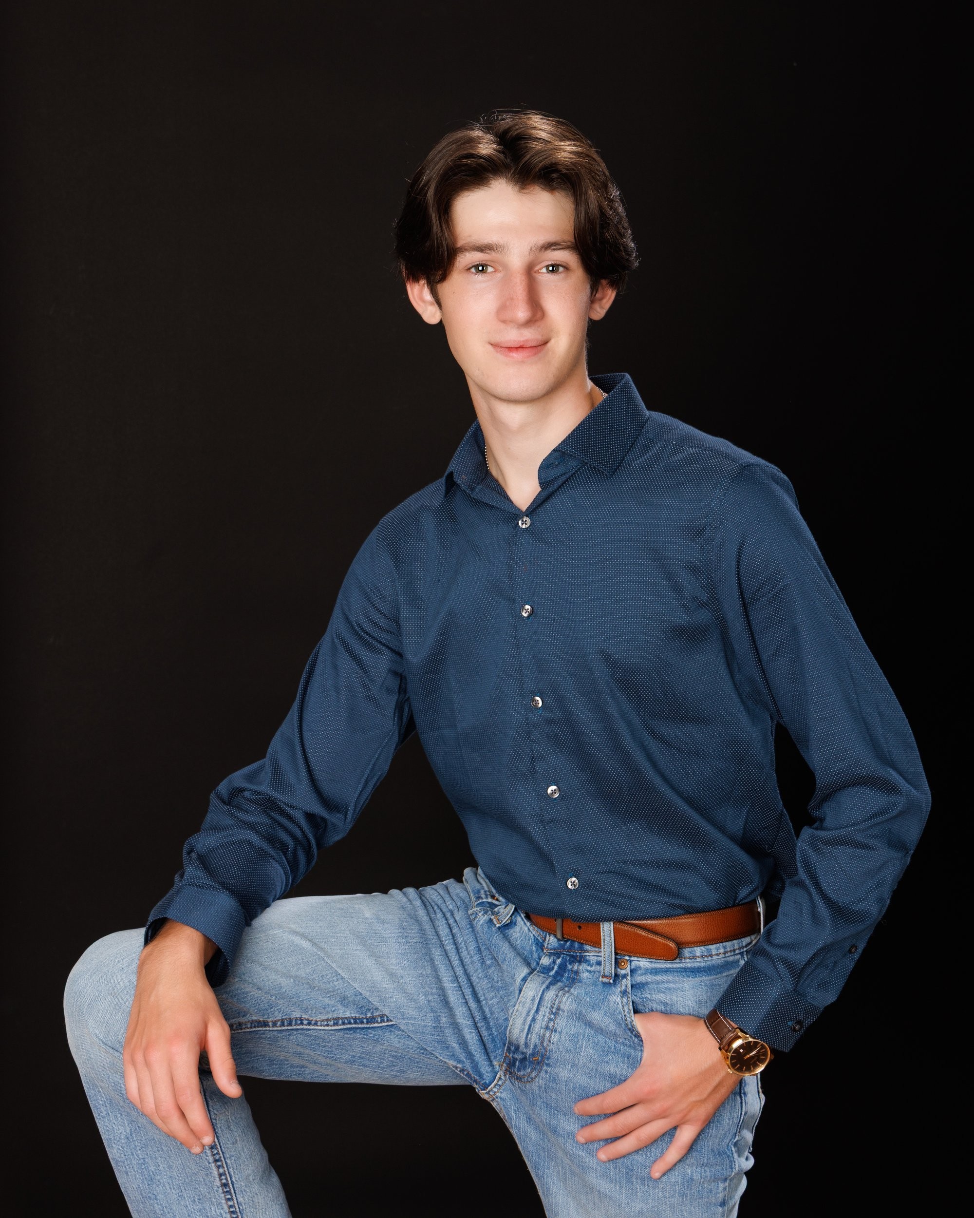 Nolan holding 'Class of 2026' chalkboard for senior graduation photo shoot