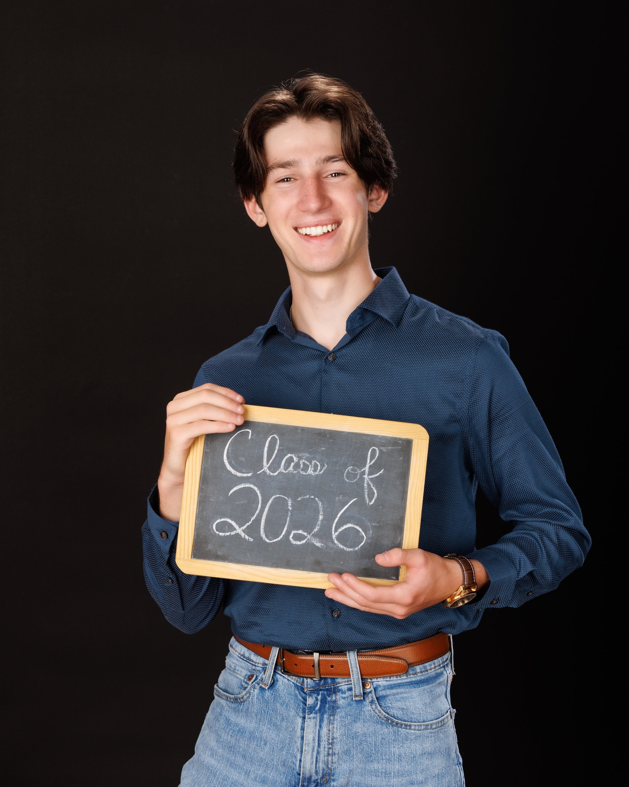 Nolan holding 'Class of 2026' chalkboard for senior graduation photo shoot