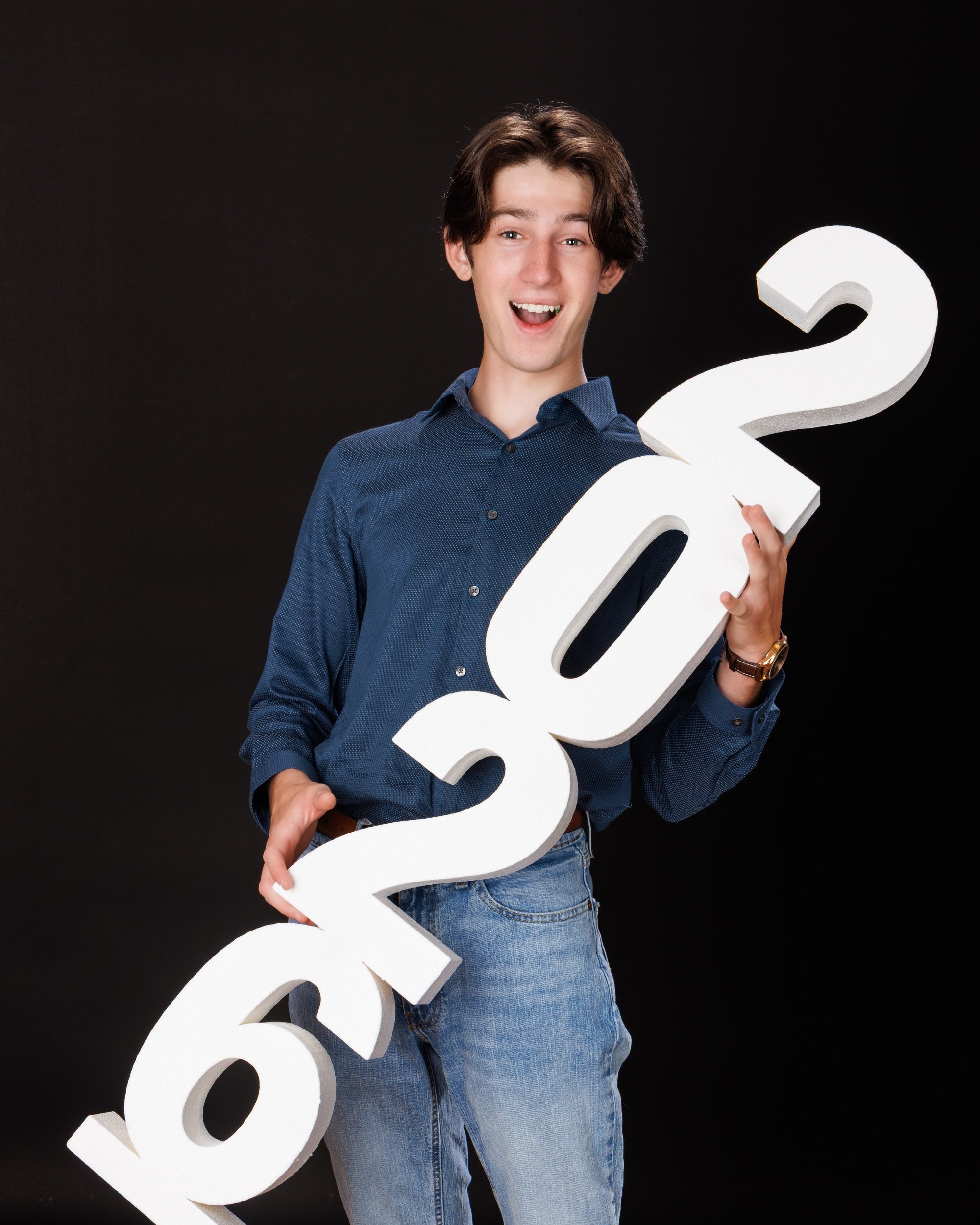 Nolan holding 'Class of 2026' chalkboard for senior graduation photo shoot