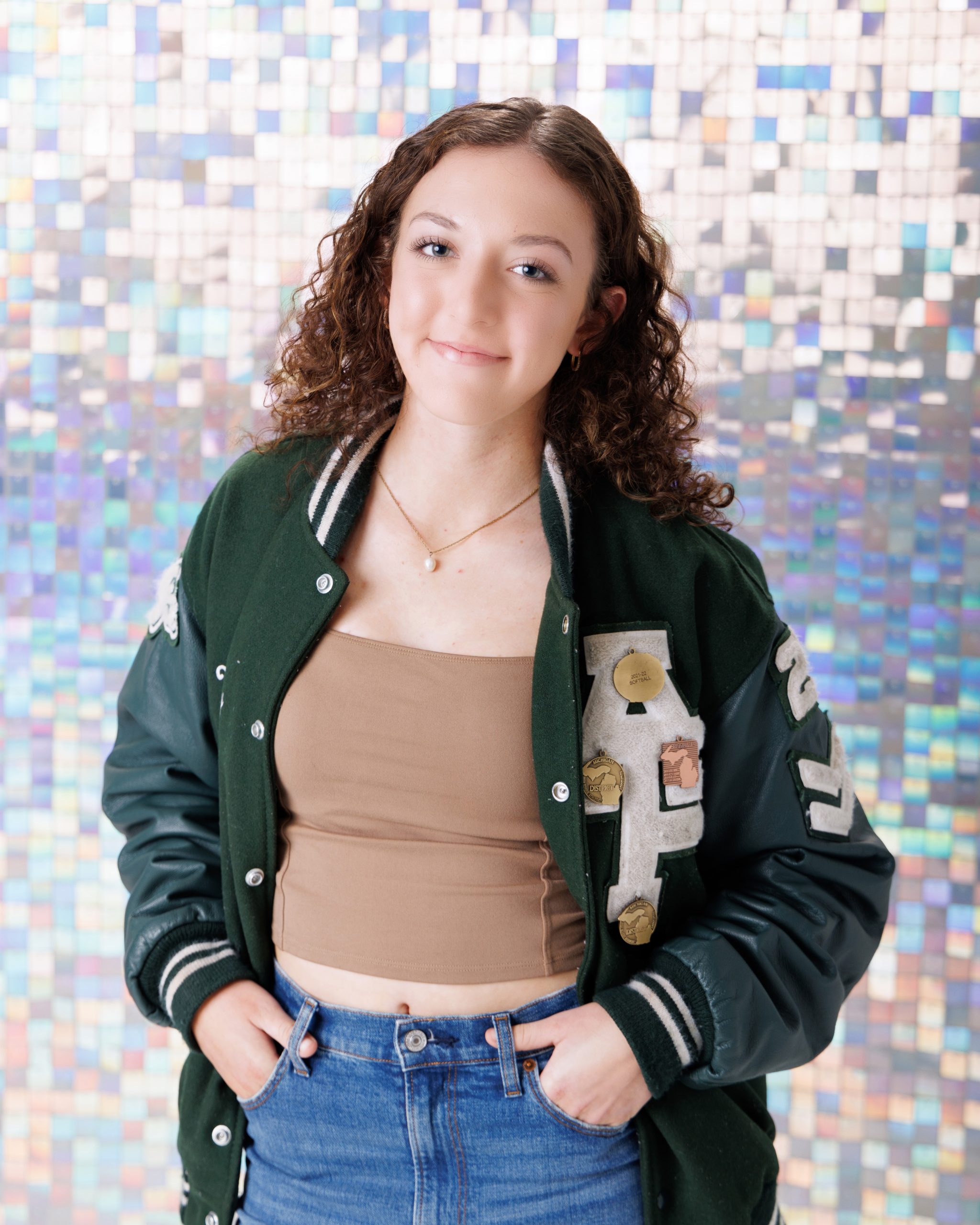 Graduation portrait of Melody holding 'Class of 2025' chalkboard, Downriver studio session