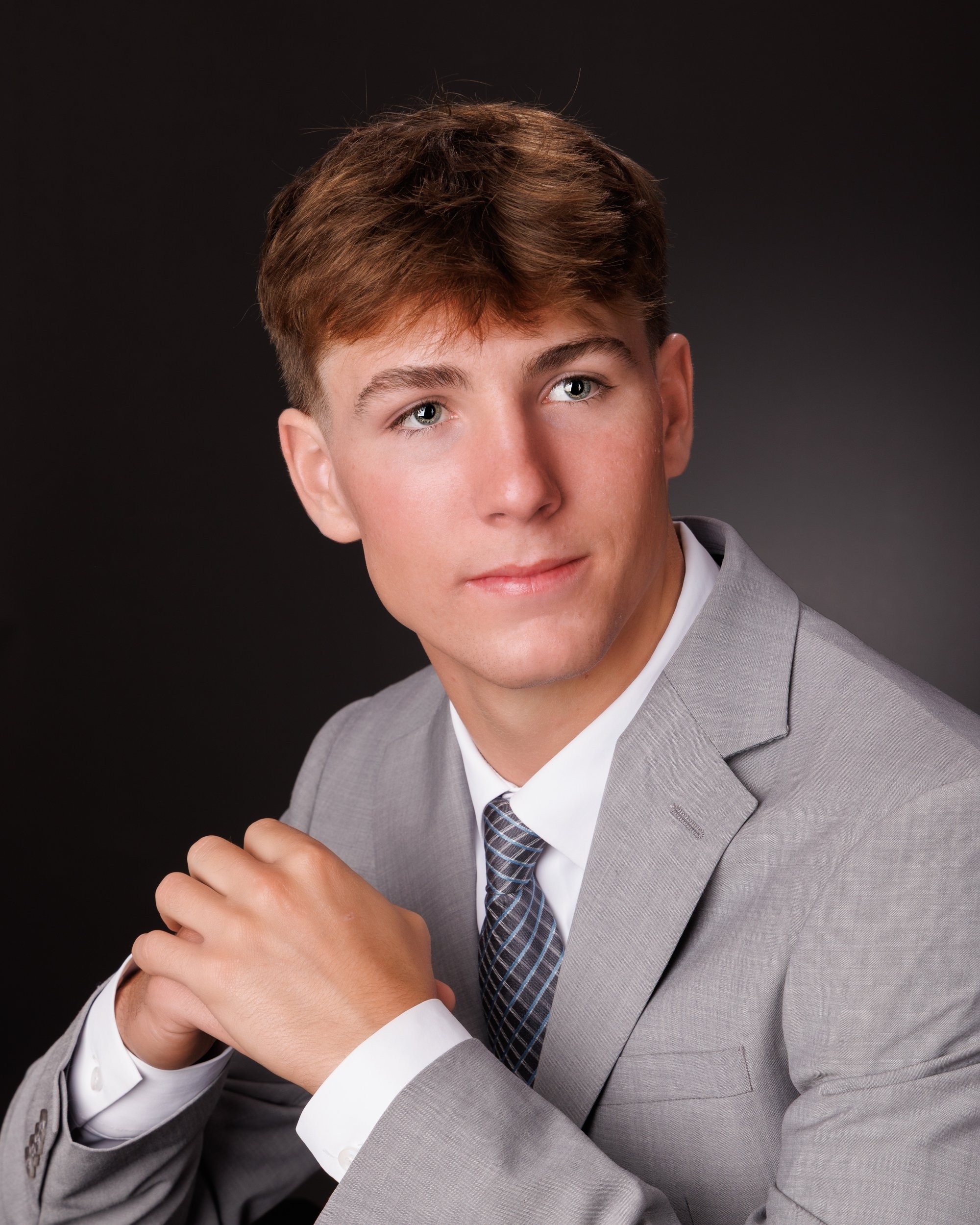 Allen Park senior Sam with football, basketball, and sports gear in studio portrait