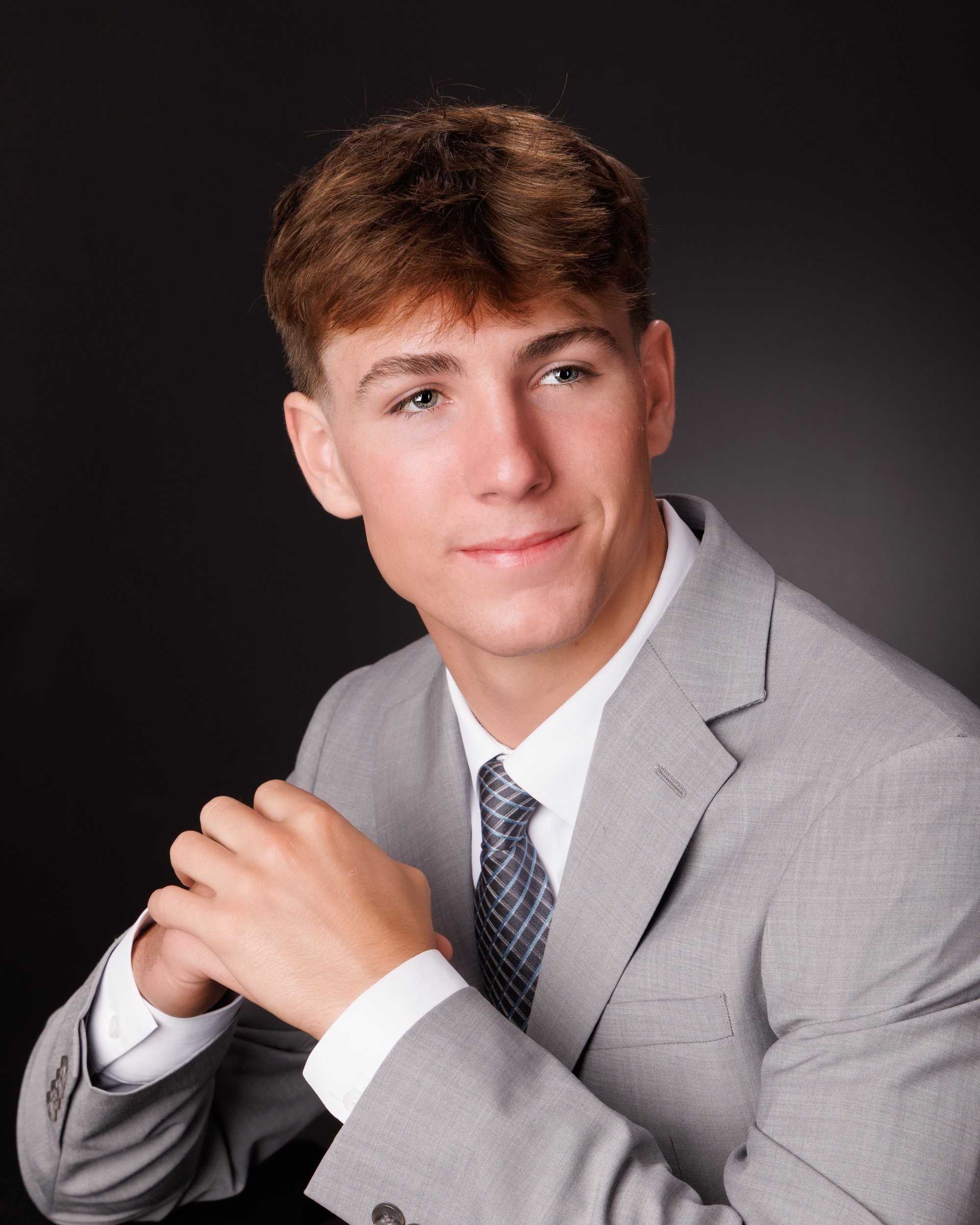 Allen Park senior Sam with football, basketball, and sports gear in studio portrait