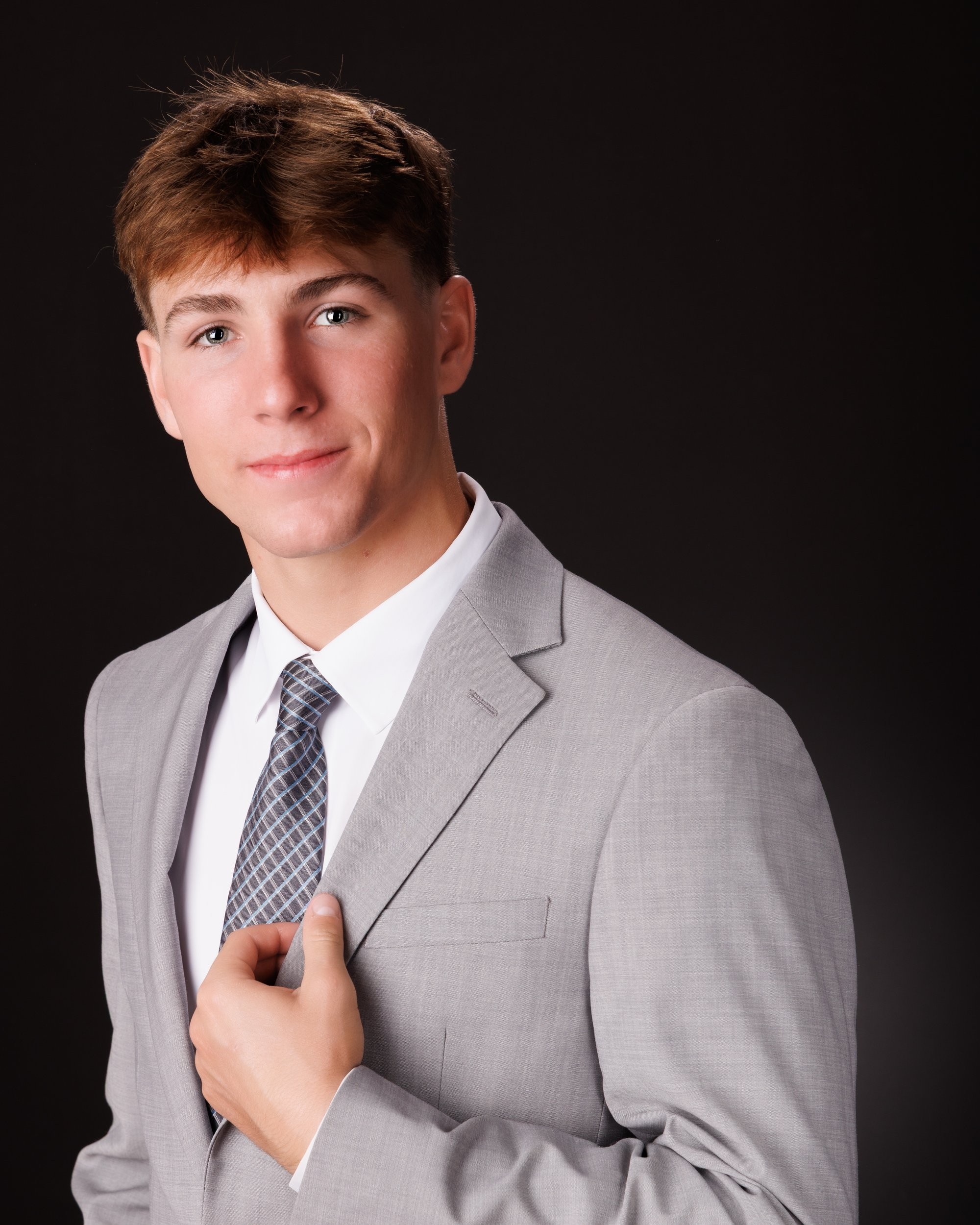 Allen Park senior Sam with football, basketball, and sports gear in studio portrait