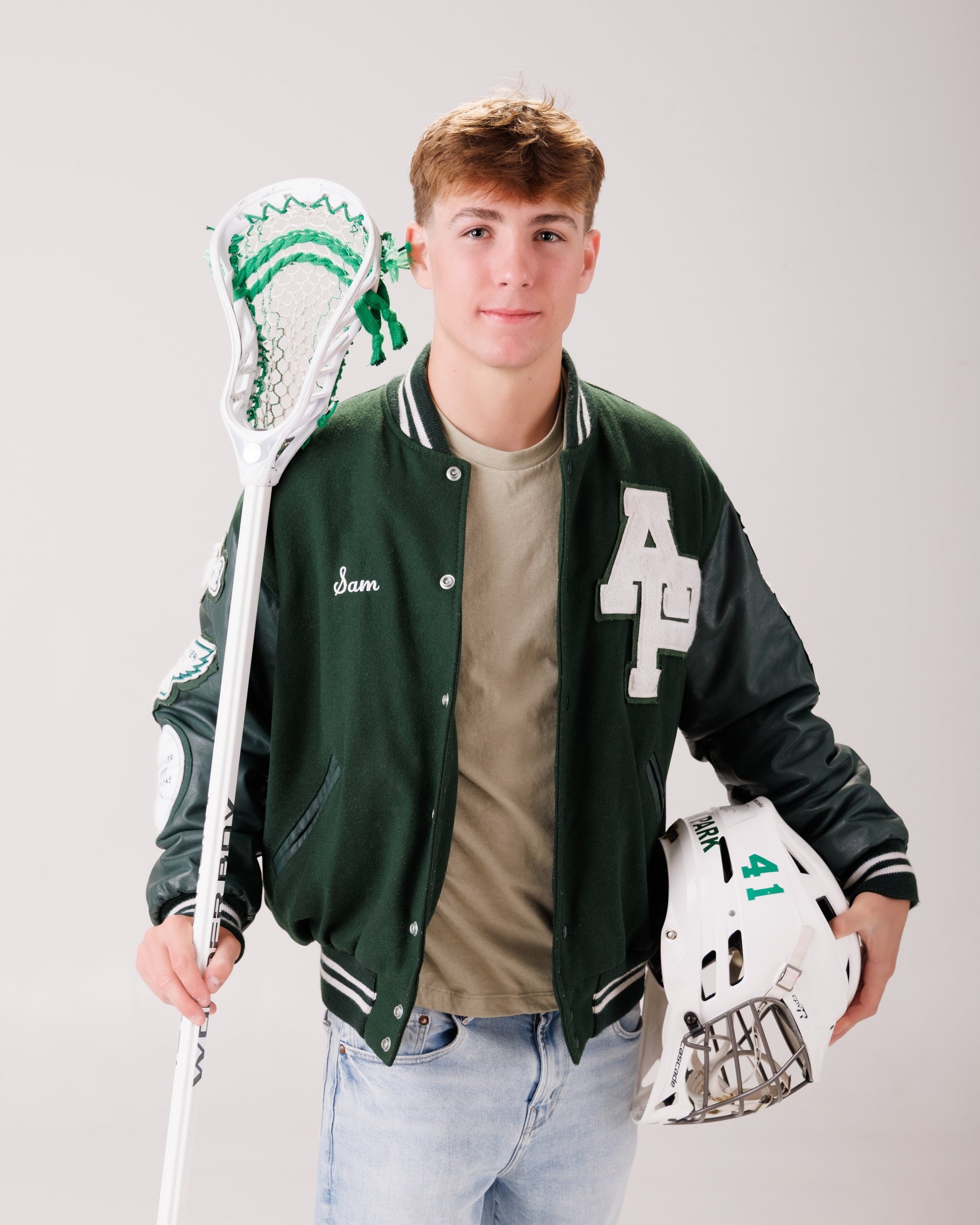 Allen Park senior Sam with football, basketball, and sports gear in studio portrait