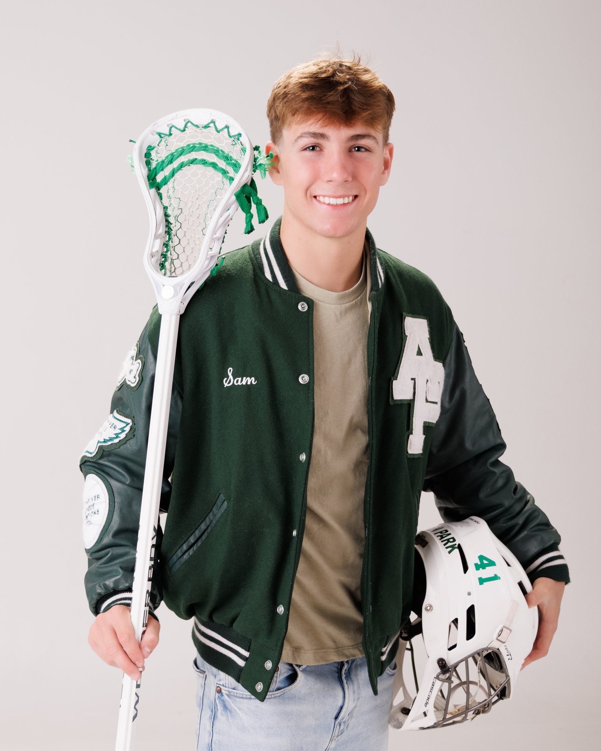 Allen Park senior Sam with football, basketball, and sports gear in studio portrait