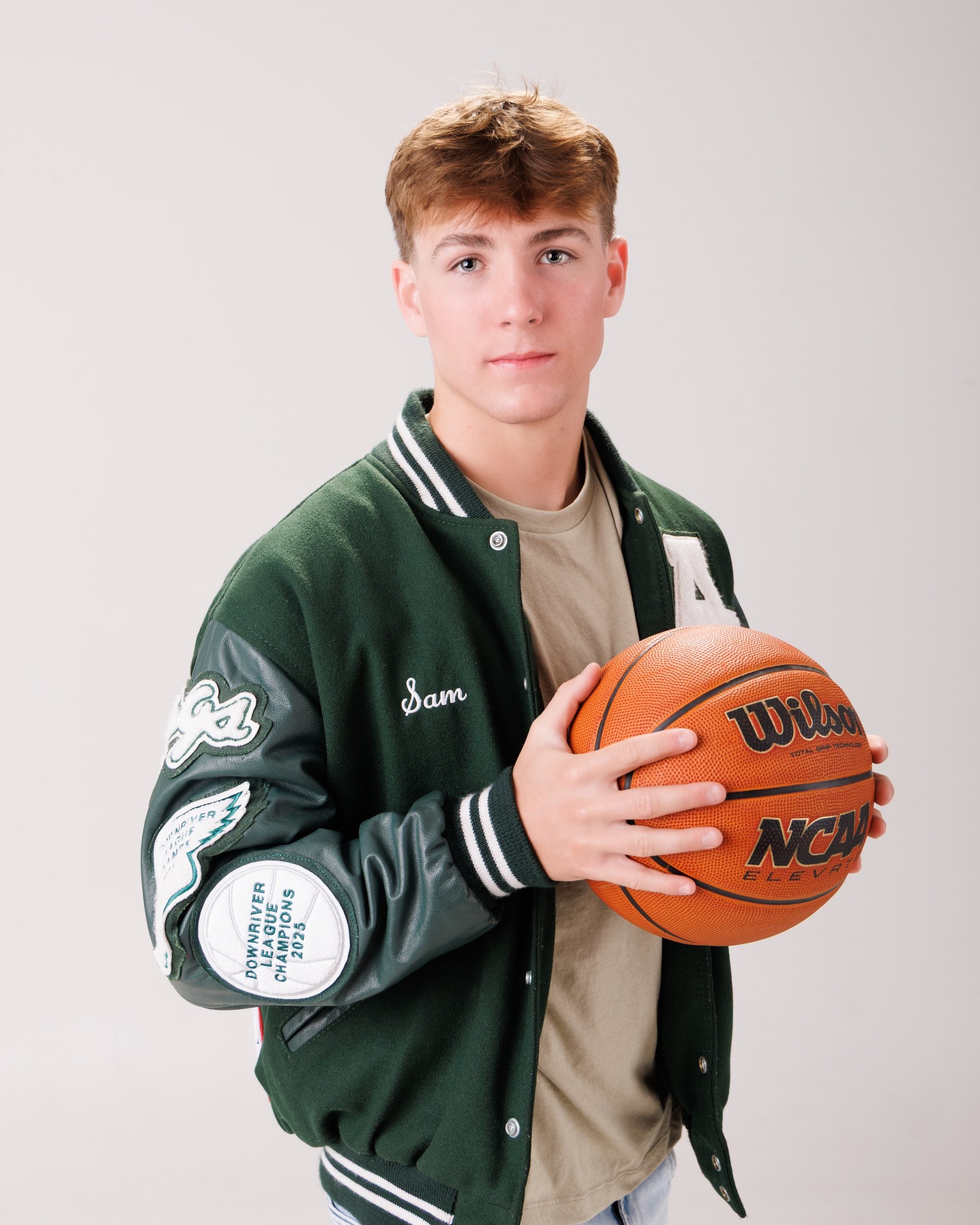 Allen Park senior Sam with football, basketball, and sports gear in studio portrait
