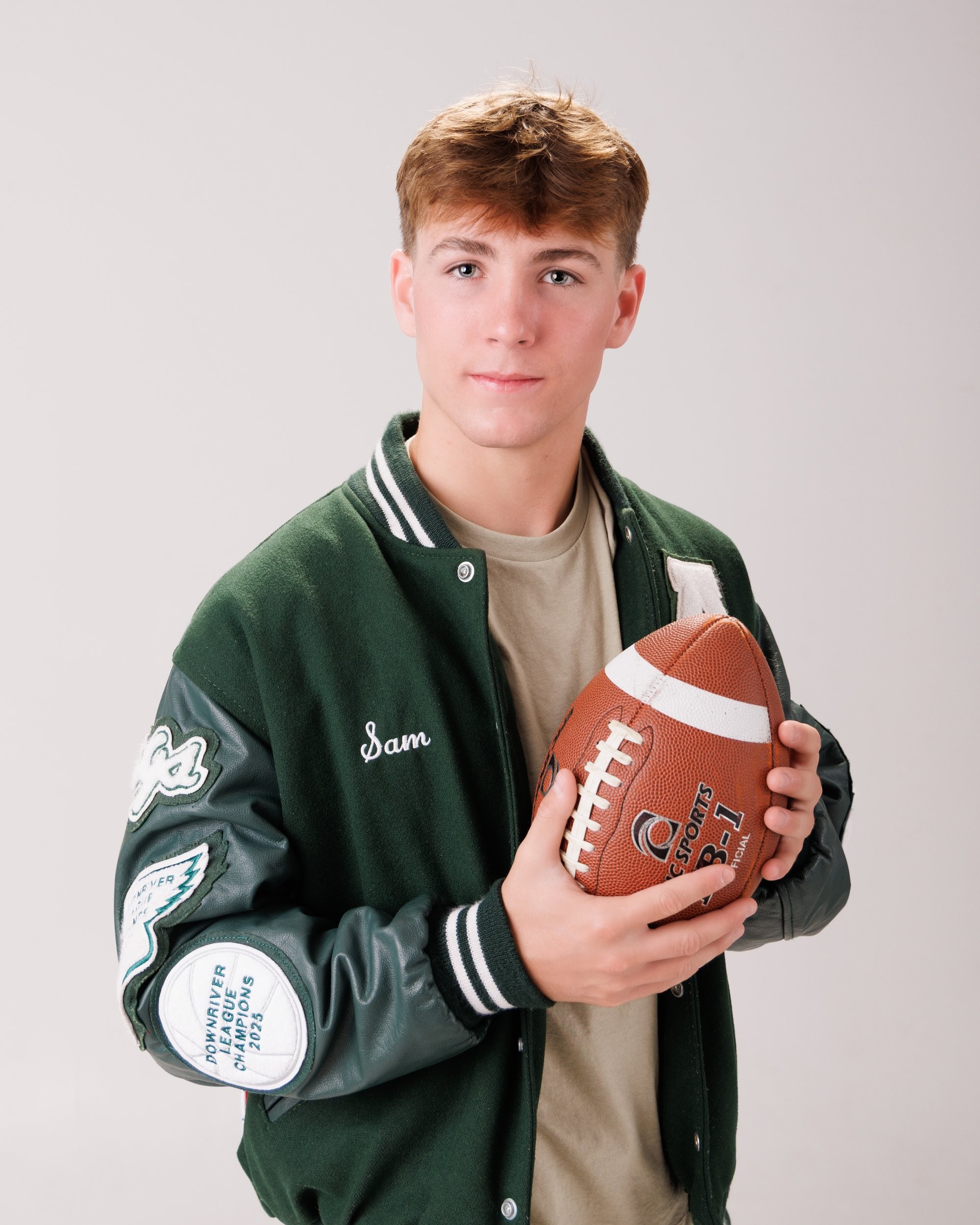 Allen Park senior Sam with football, basketball, and sports gear in studio portrait