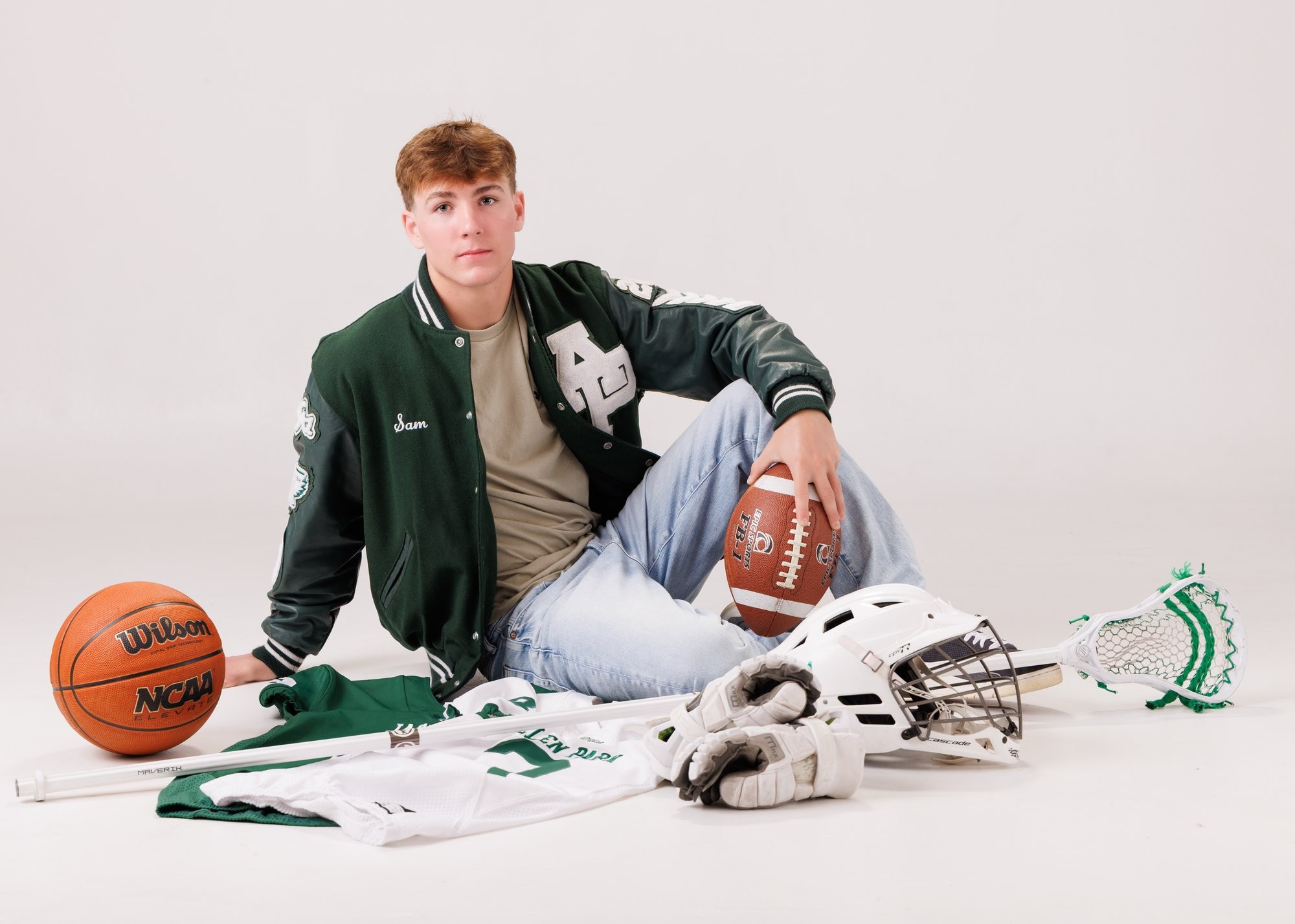 Allen Park senior Sam with football, basketball, and sports gear in studio portrait