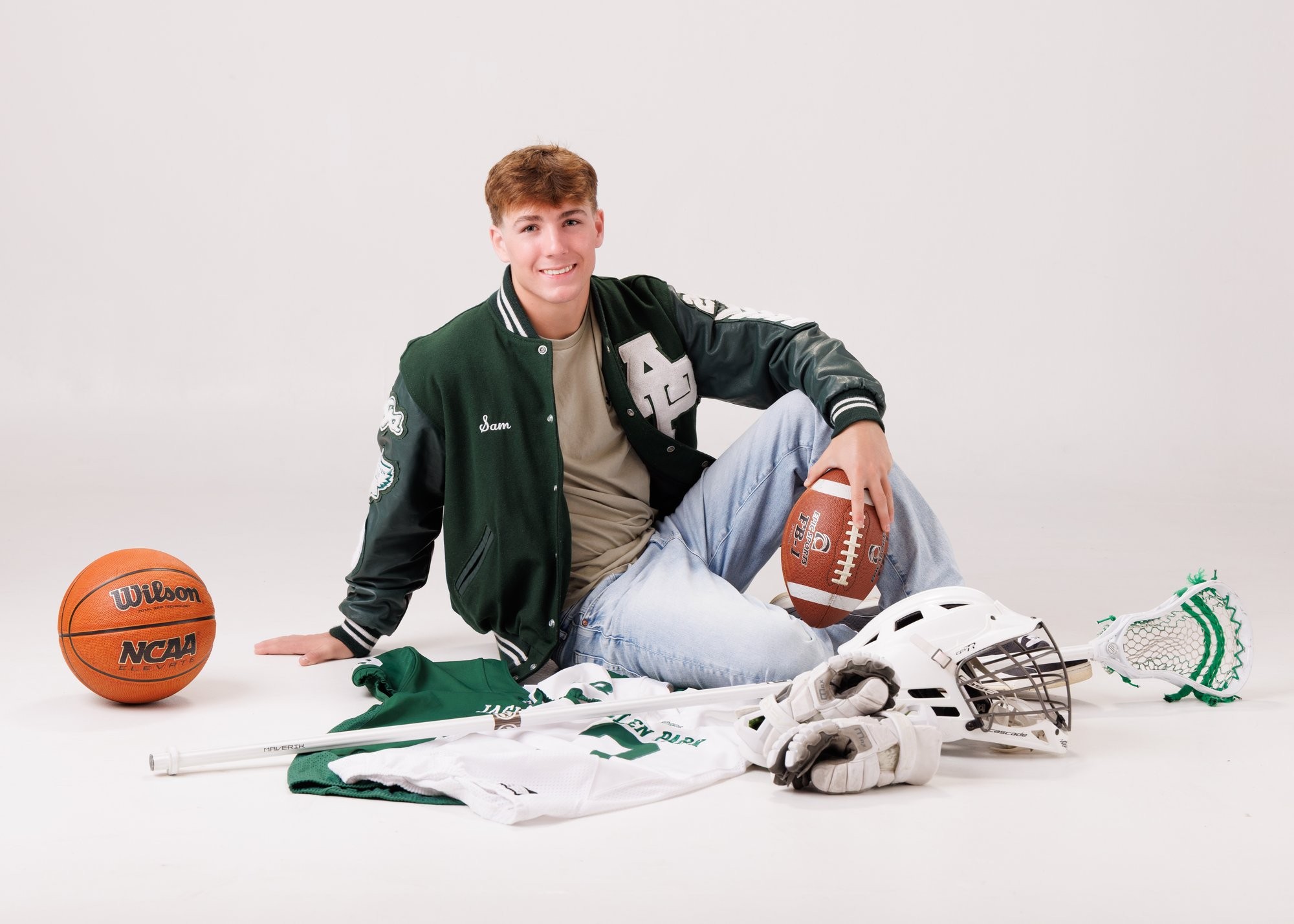 Allen Park senior Sam with football, basketball, and sports gear in studio portrait
