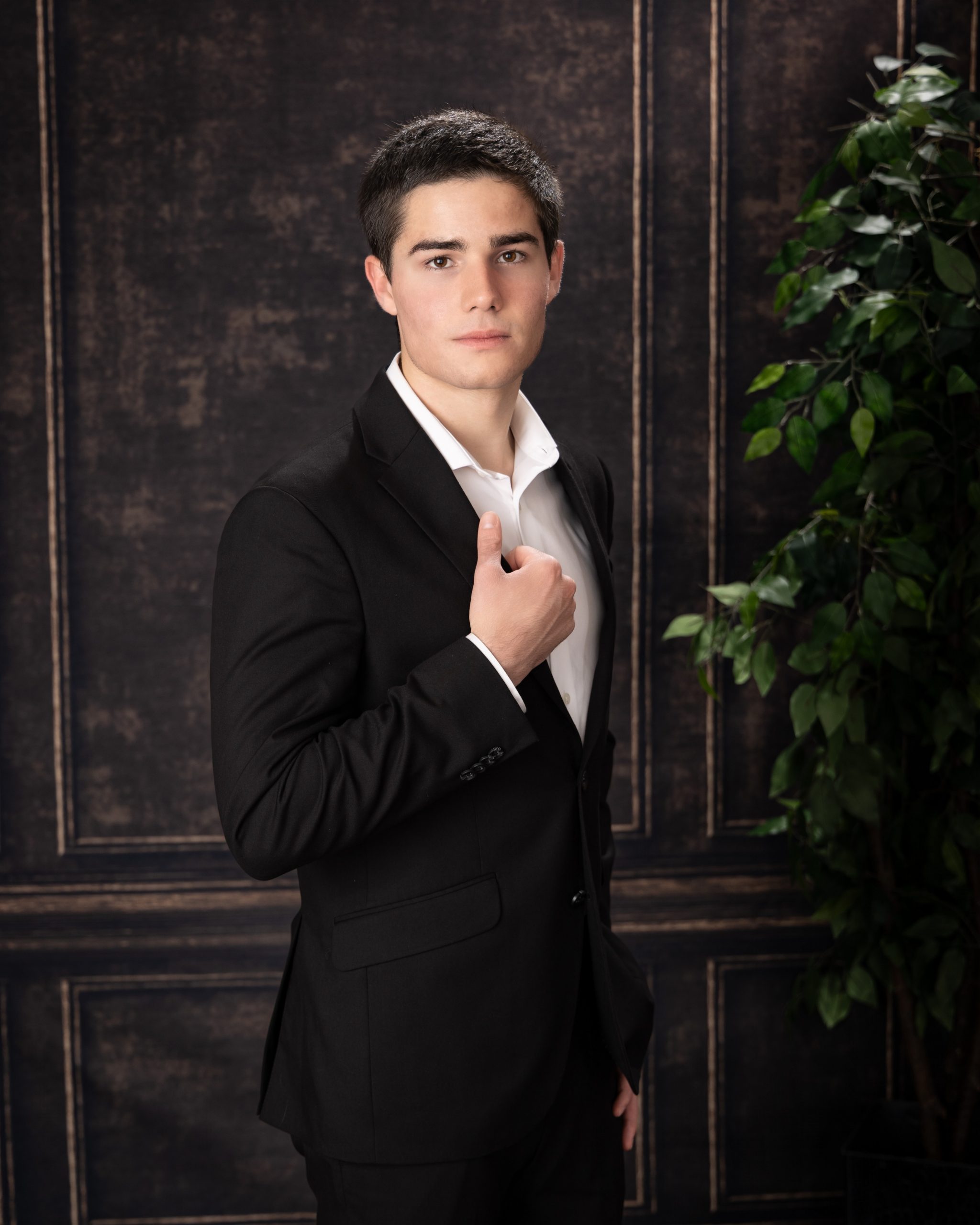High school senior adjusting suit jacket during Downriver photography session