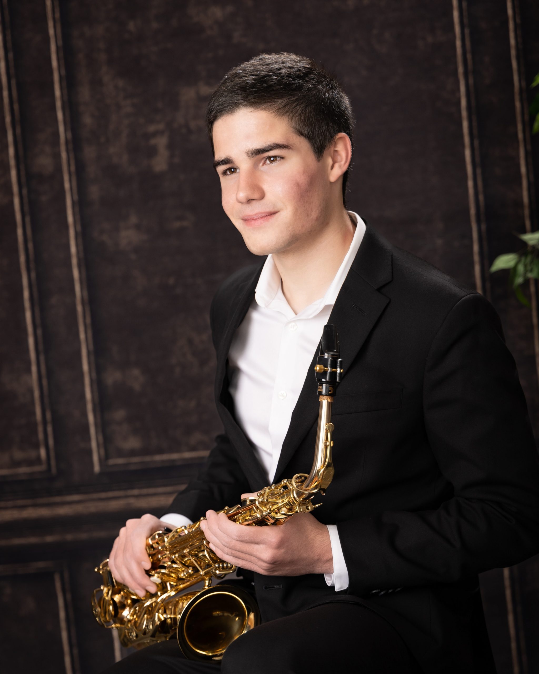 Senior posing with saxophone in professional studio environment