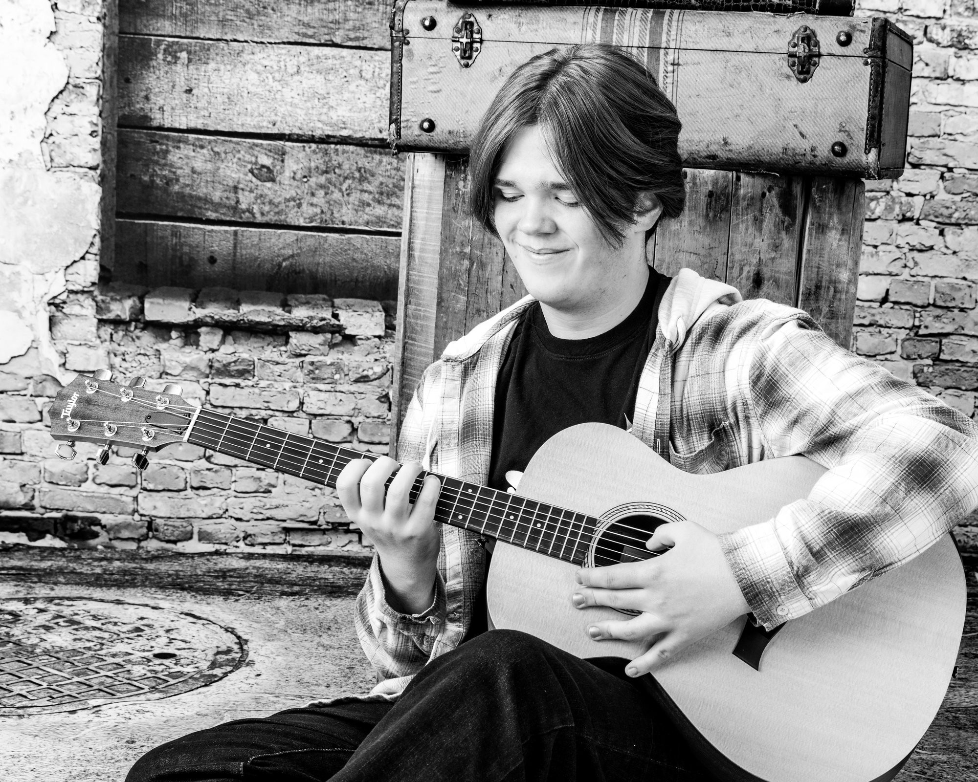 Senior portrait featuring an acoustic guitar against a dark gradient background, showcasing the artist's style in our Taylor photo studio
