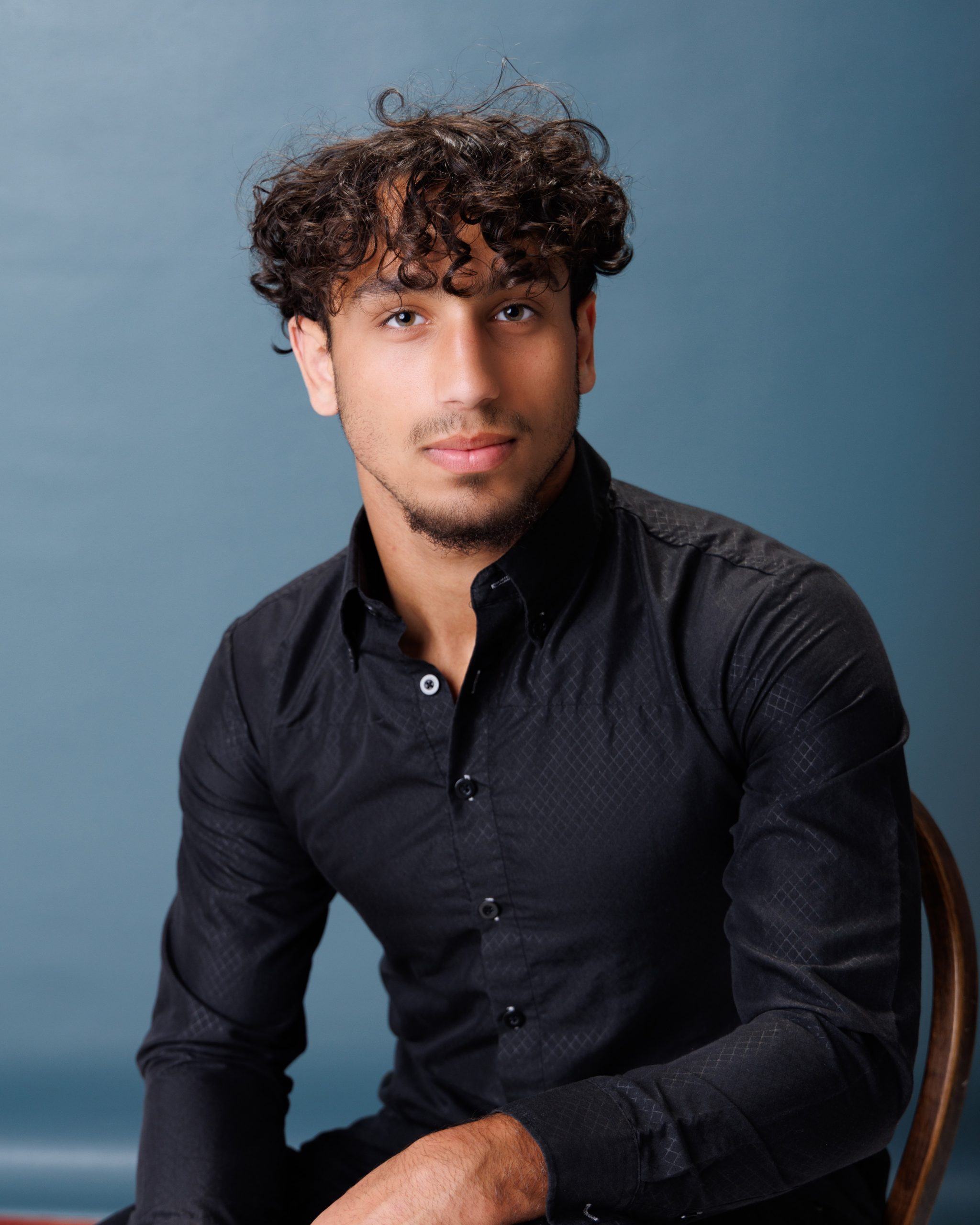 young man posing with football during Allen Park senior photography