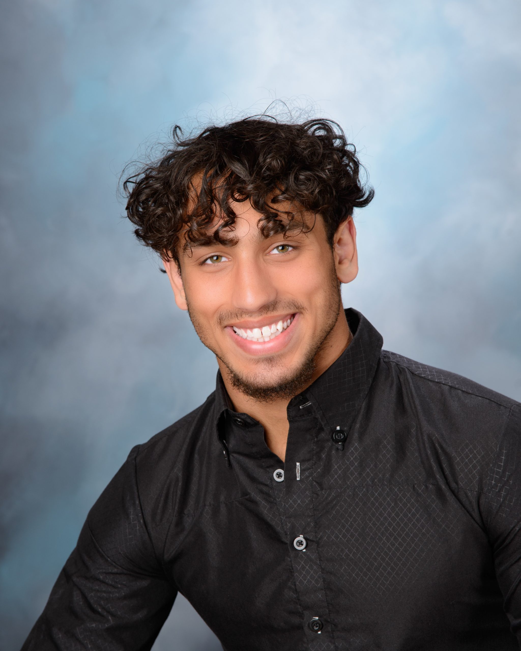 young man posing with football during Allen Park senior photography