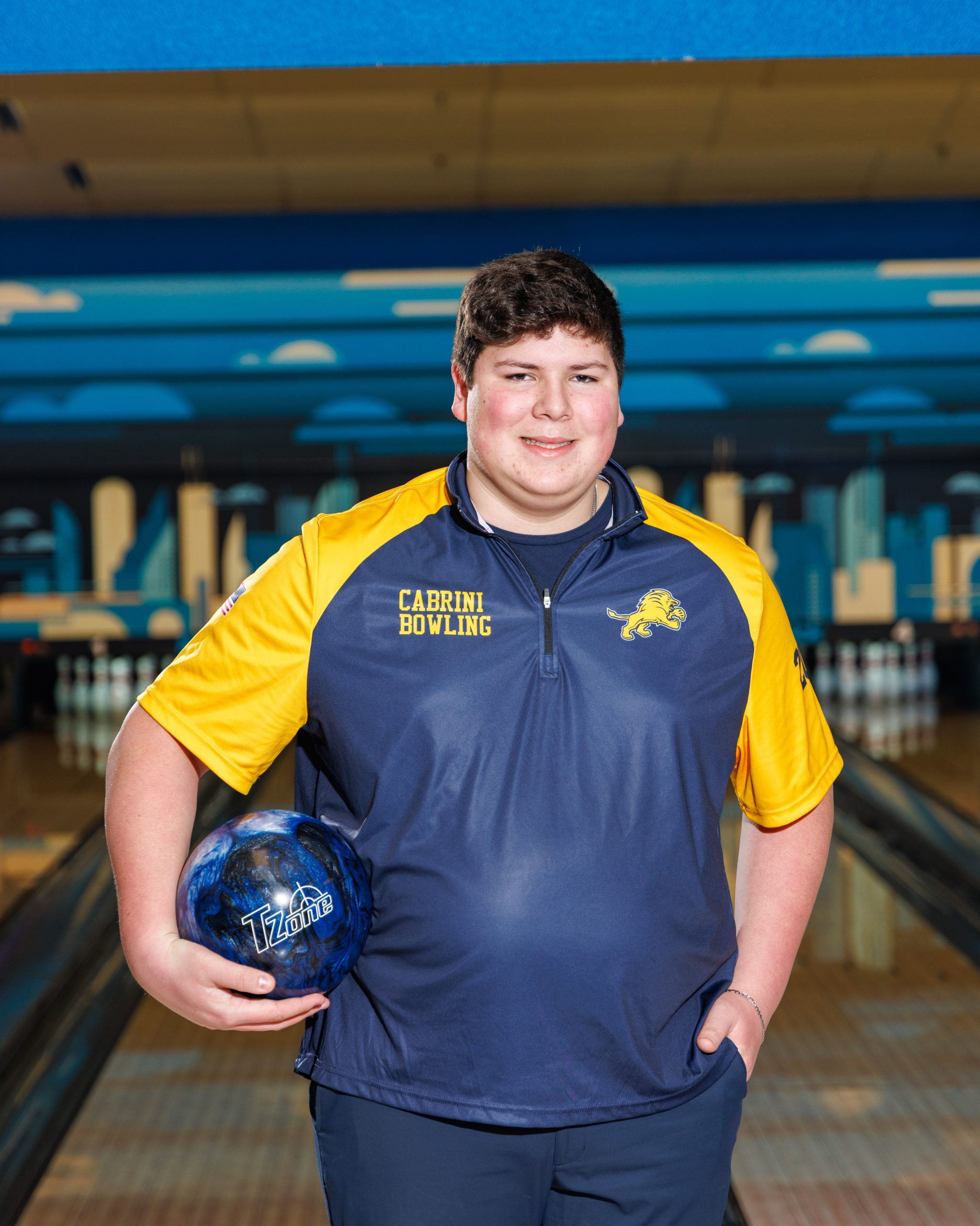 Cabrini Bowling team member with purple bowling ball at bowling alley