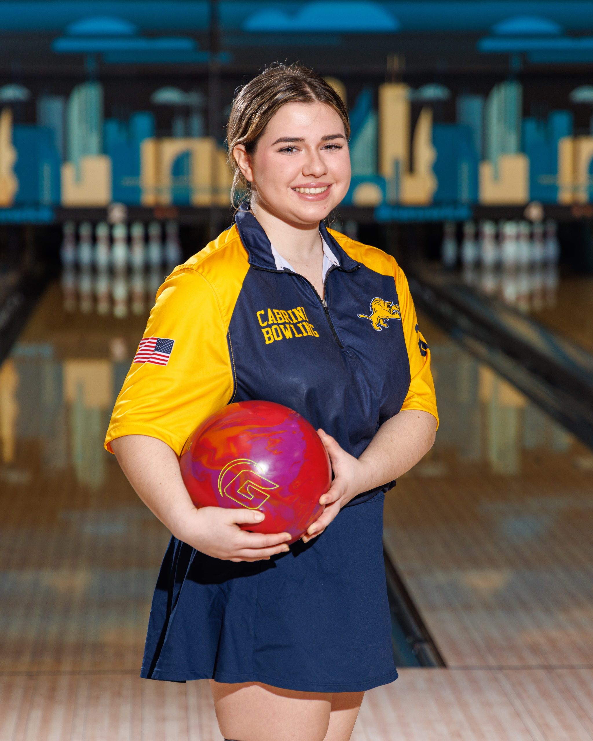 Cabrini Bowling player lying on floor with red bowling ball