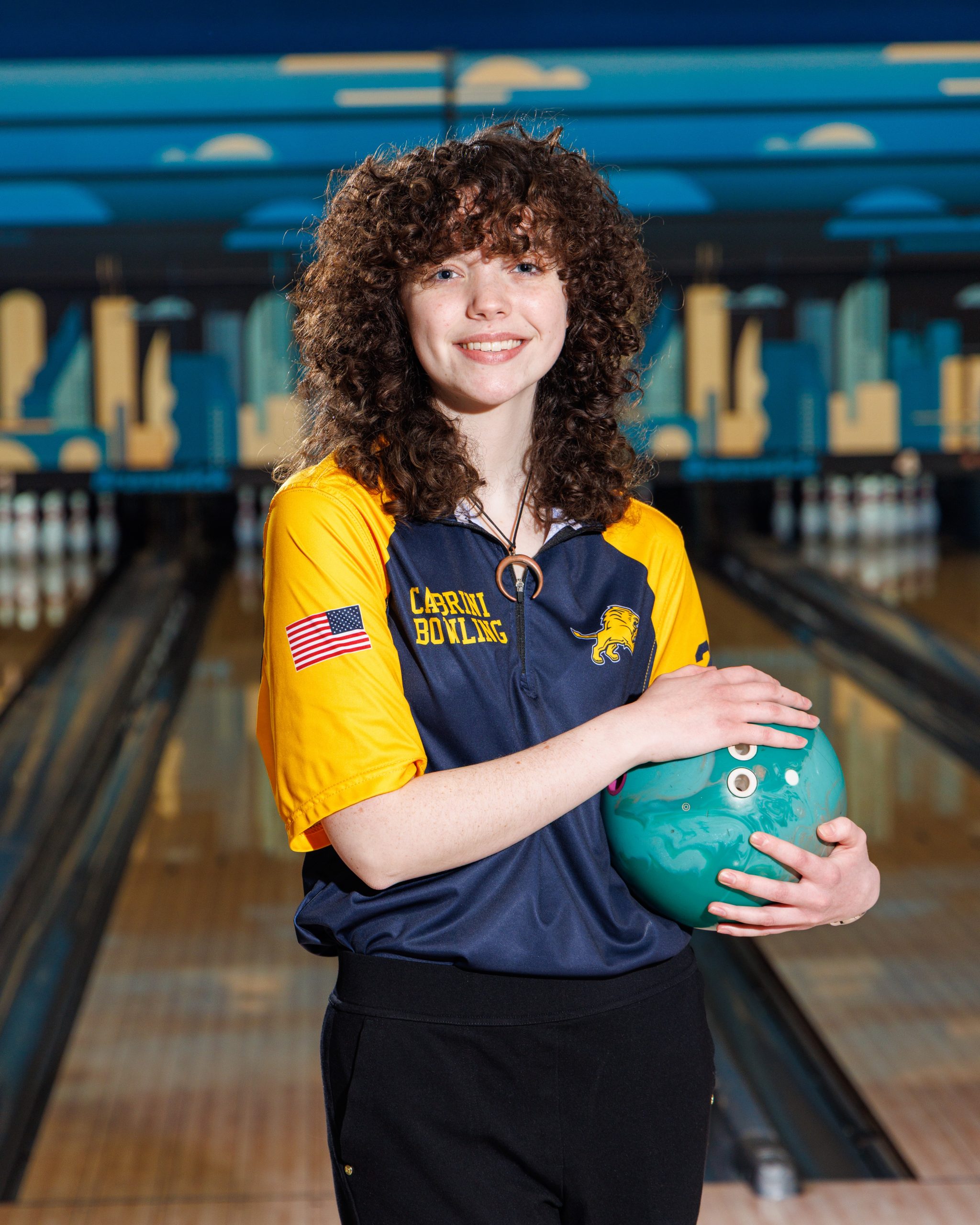Cabrini Bowling player lying on floor with red bowling ball