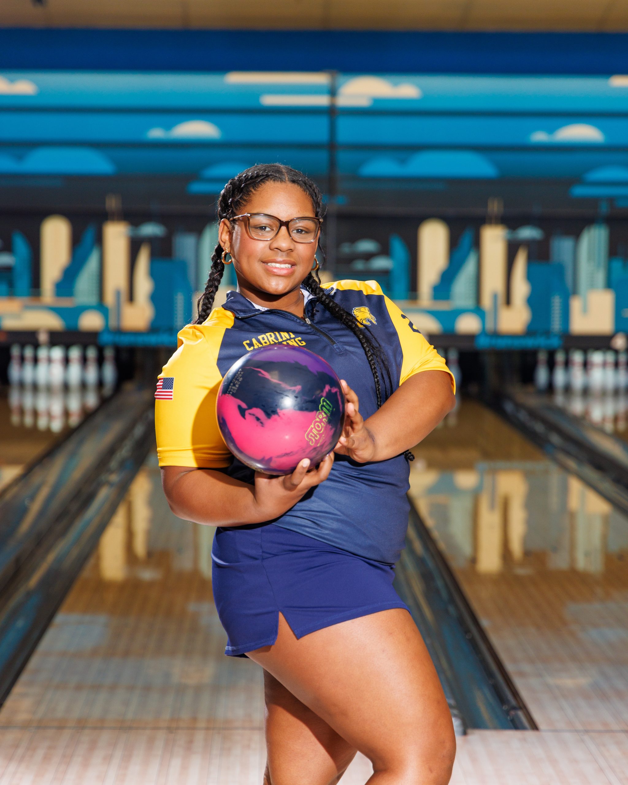 Cabrini Bowling player lying on floor with red bowling ball