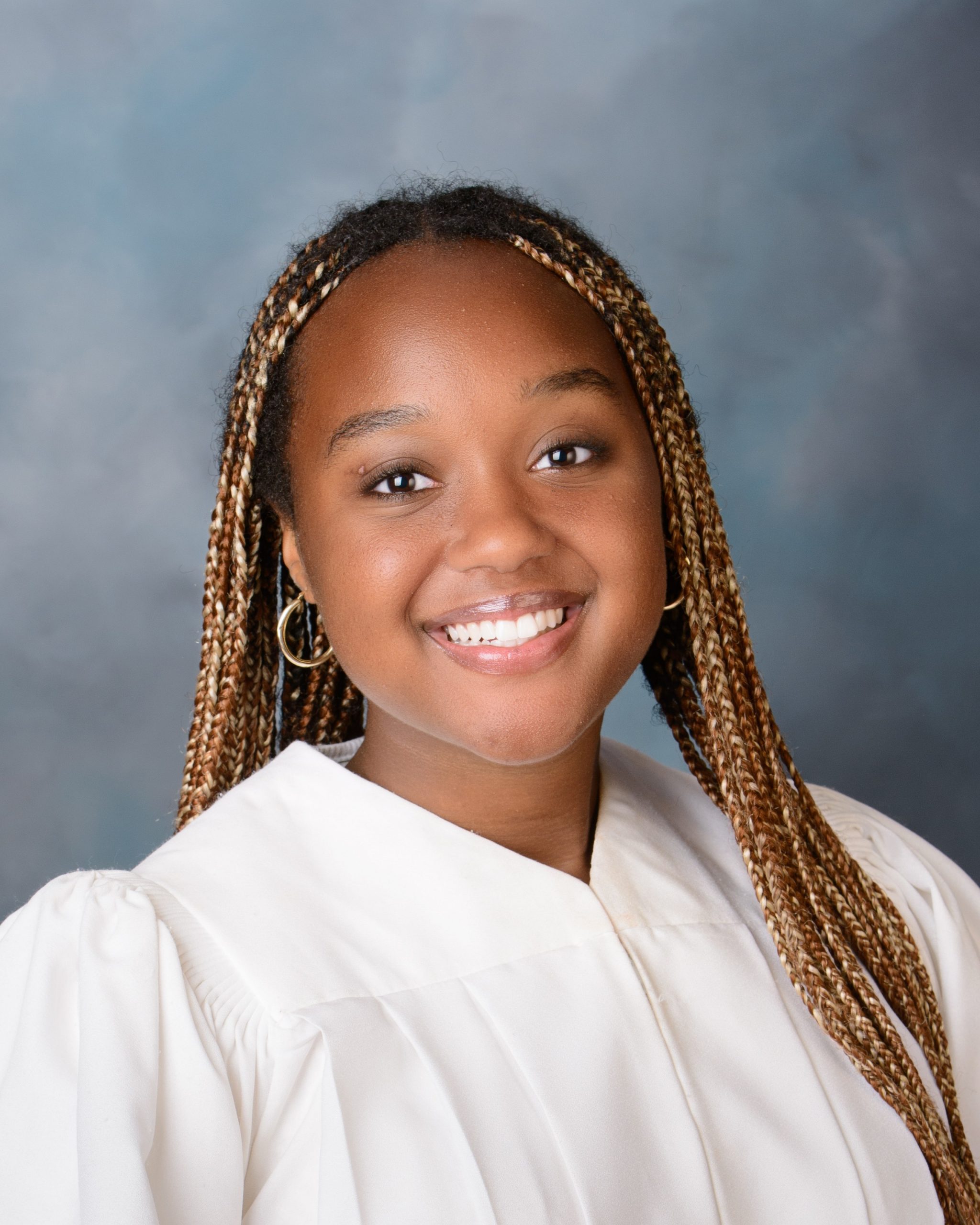 Cabrini Senior Faith in graduation gown, smiling during a senior photography session at our photo studio