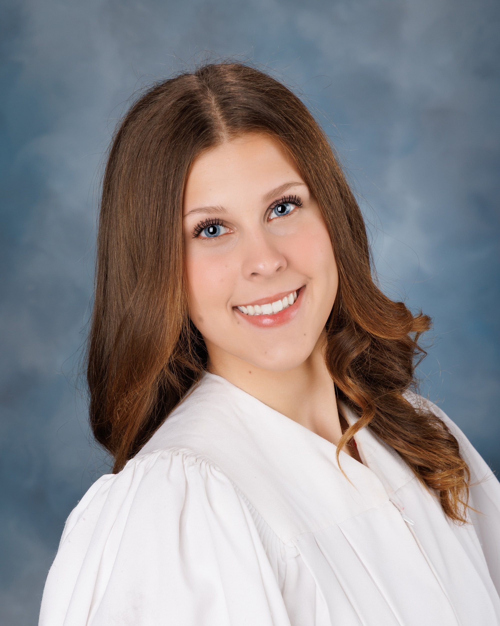 Cabrini Senior student Isabella's vibrant pink mosaic background portrait, white blouse, and cross necklace