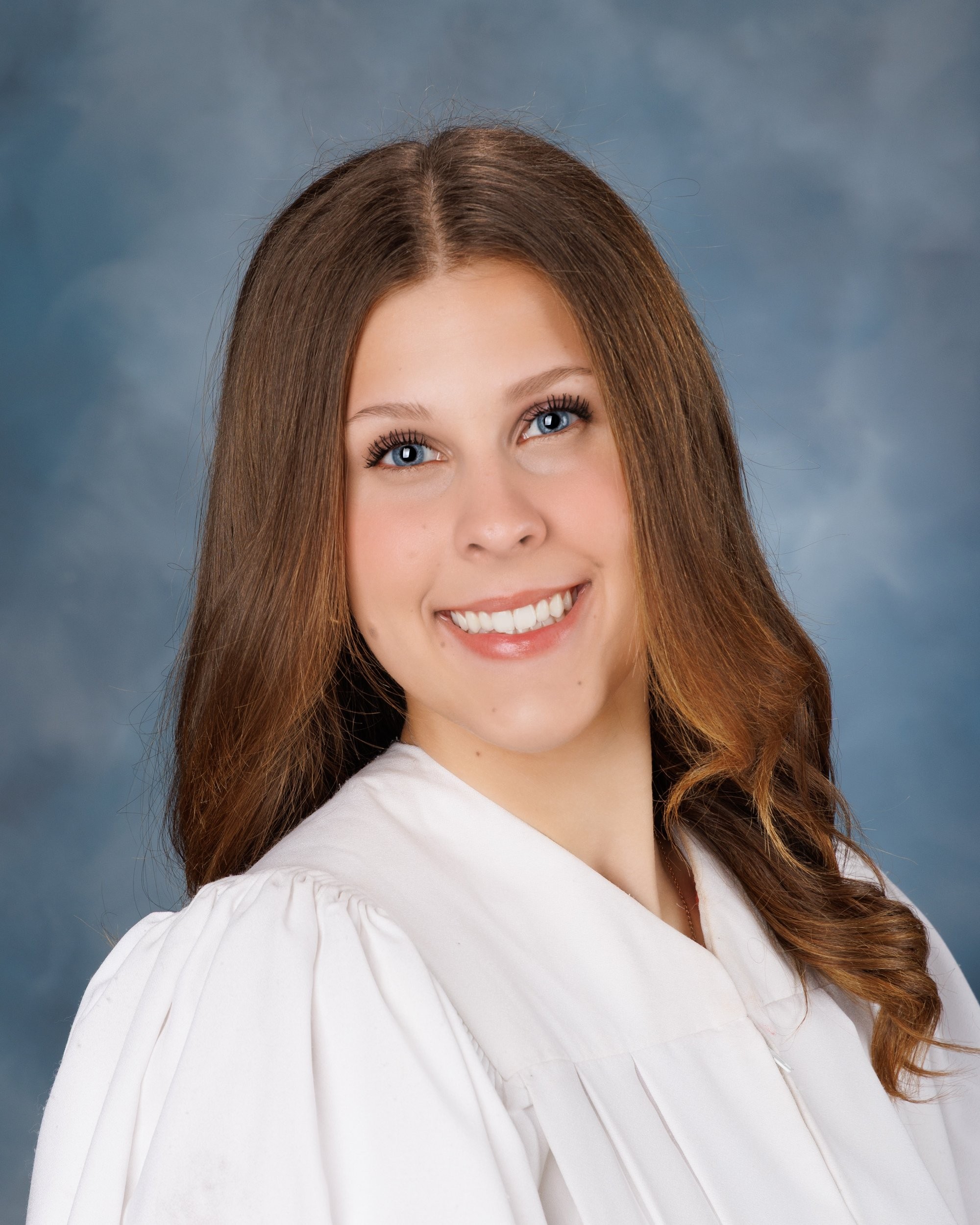 Cabrini Senior student Isabella's vibrant pink mosaic background portrait, white blouse, and cross necklace