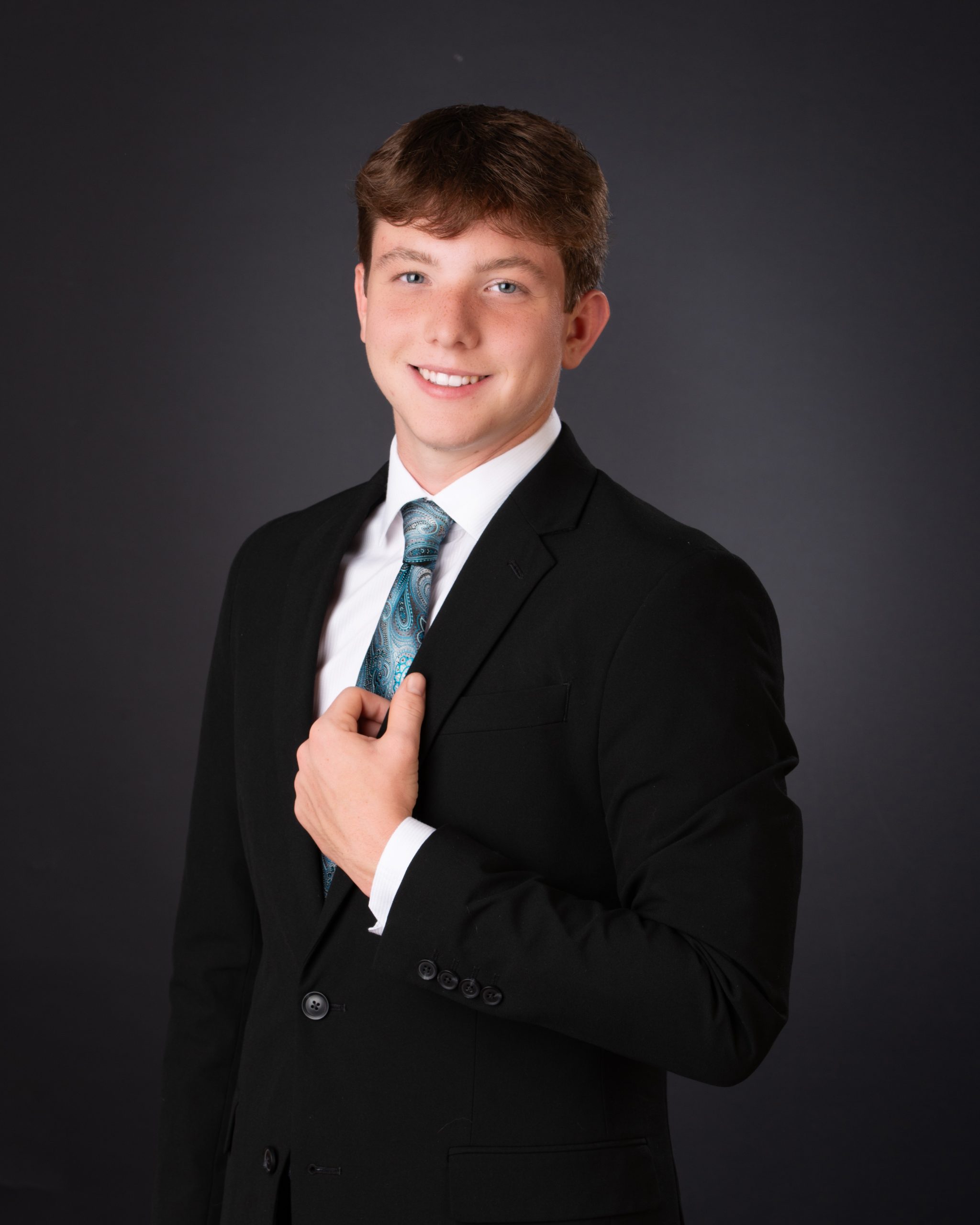 Wyatt wearing Cabrini varsity jacket with 'Cabrini' and number 24, seated against brick wall background