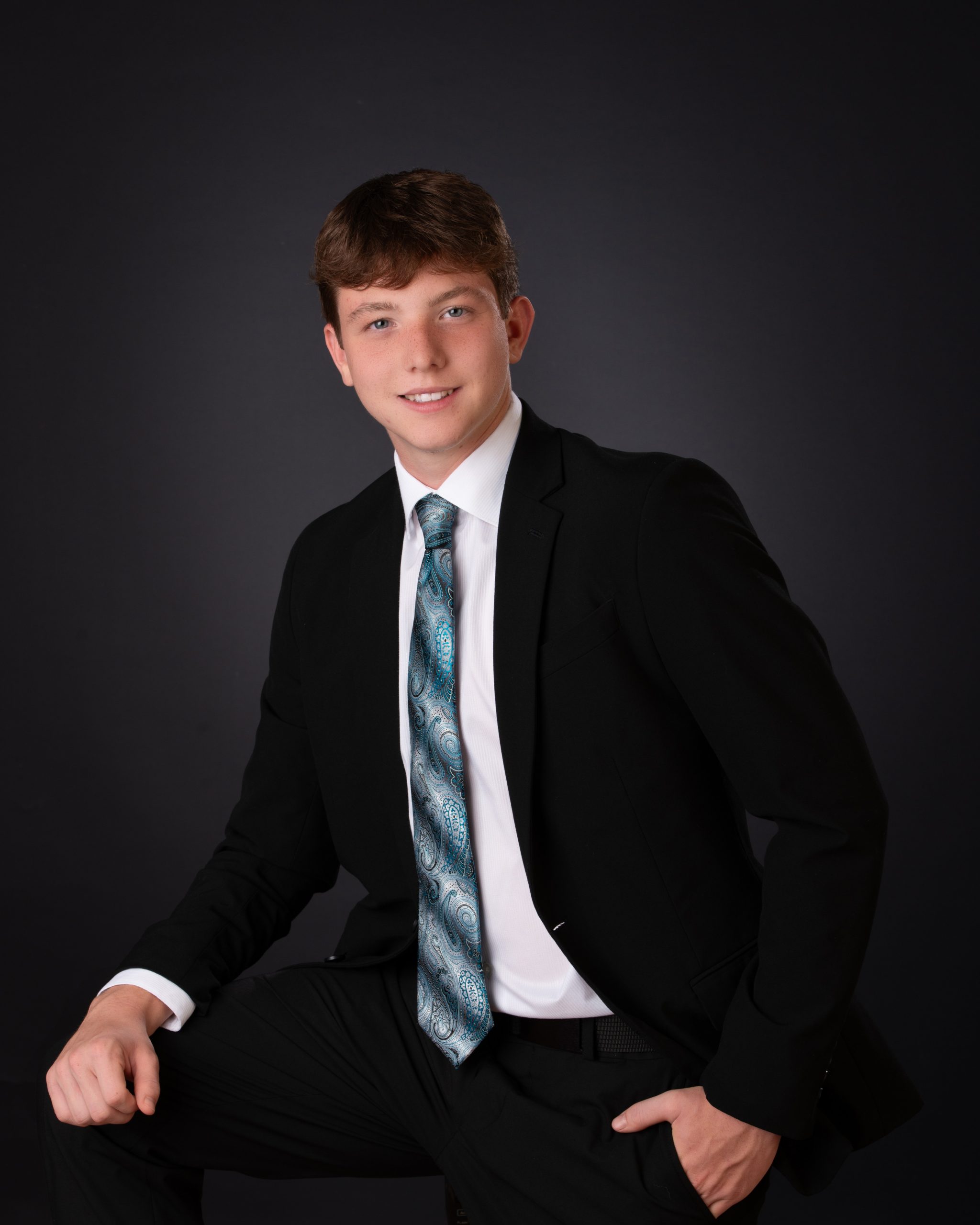 Wyatt in black Nike hoodie with graffiti art backdrop for senior photography session