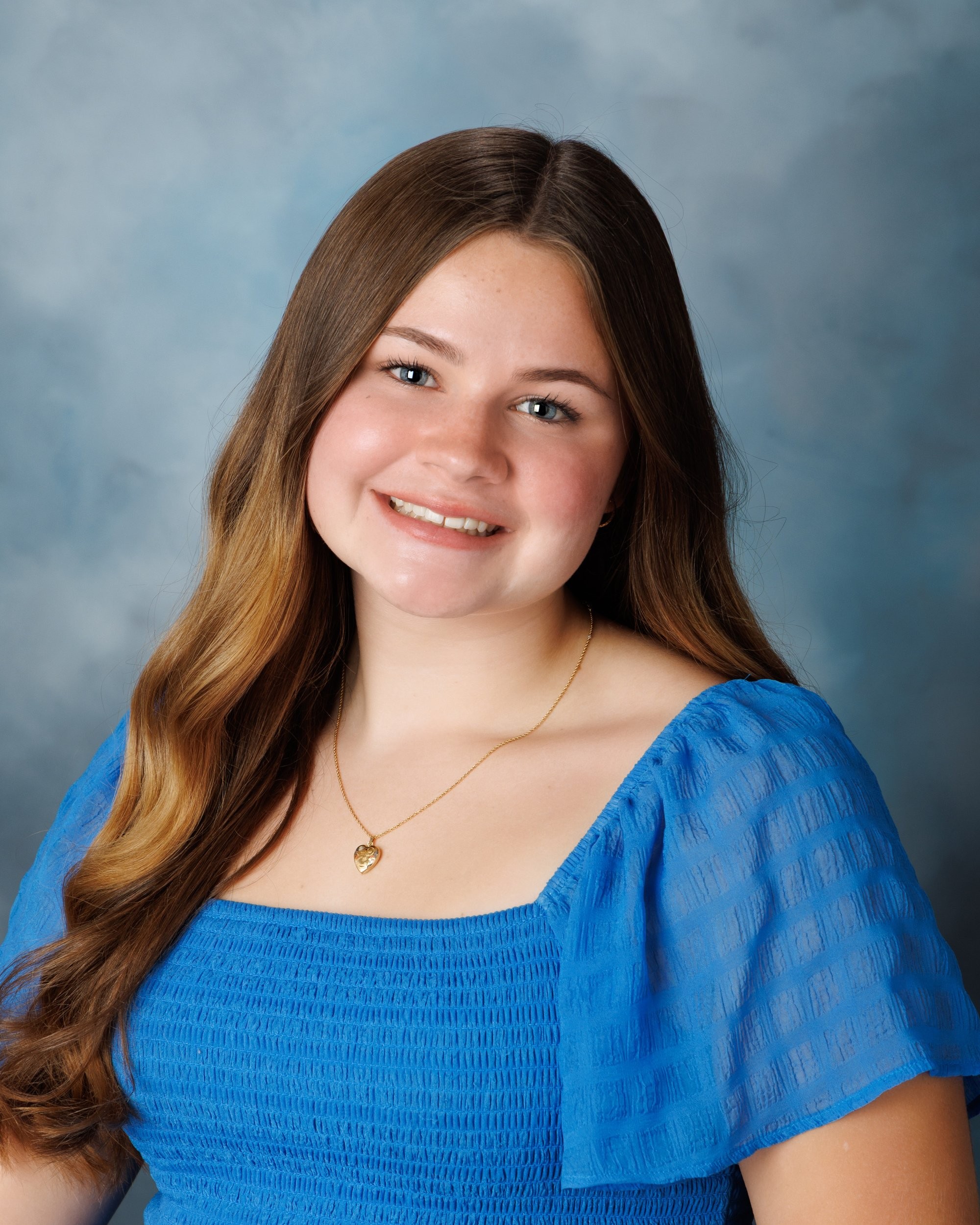 Natalie in blue dress and varsity jacket for Cabrini Senior Session photo shoot