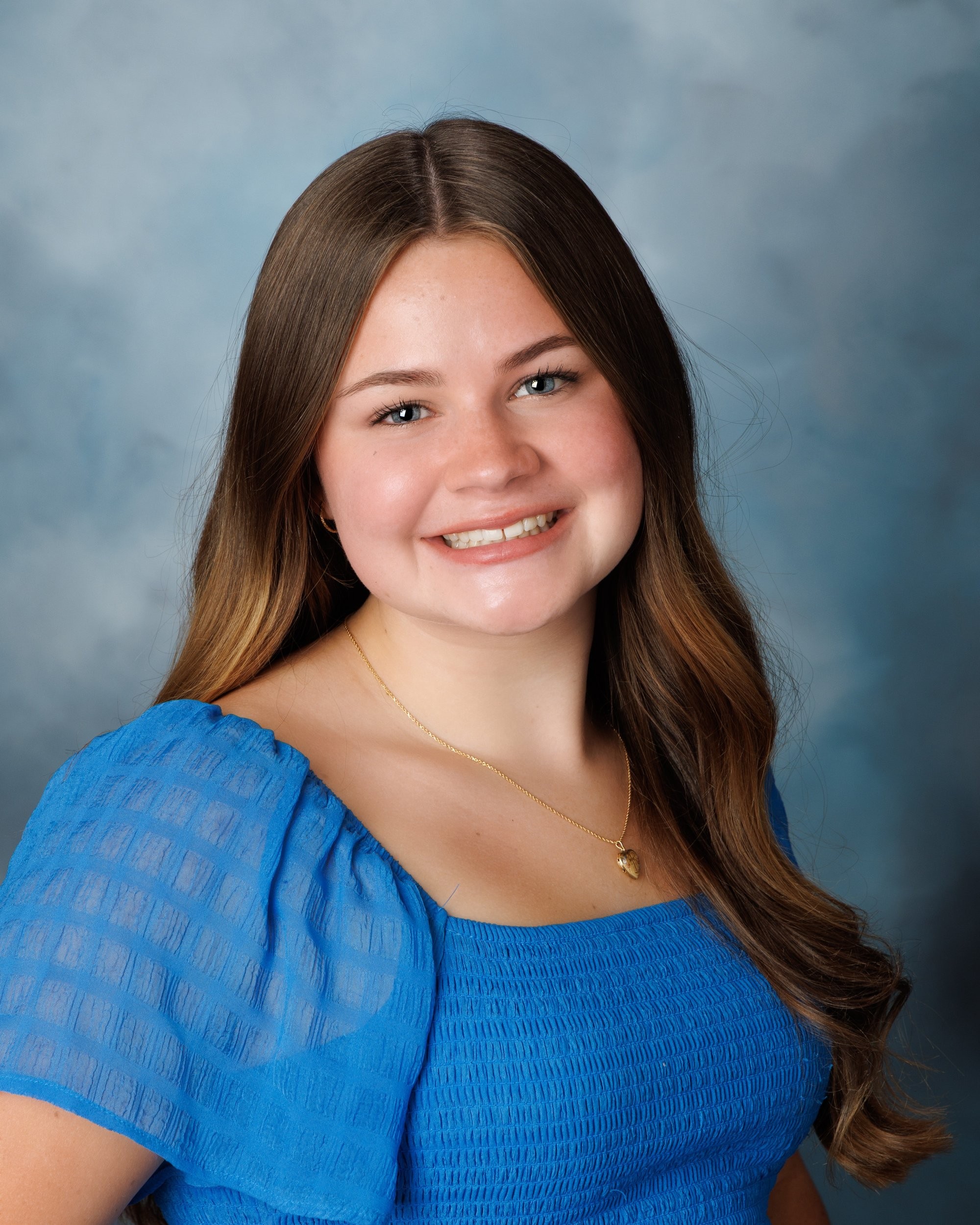 Natalie in blue dress and varsity jacket for Cabrini Senior Session photo shoot