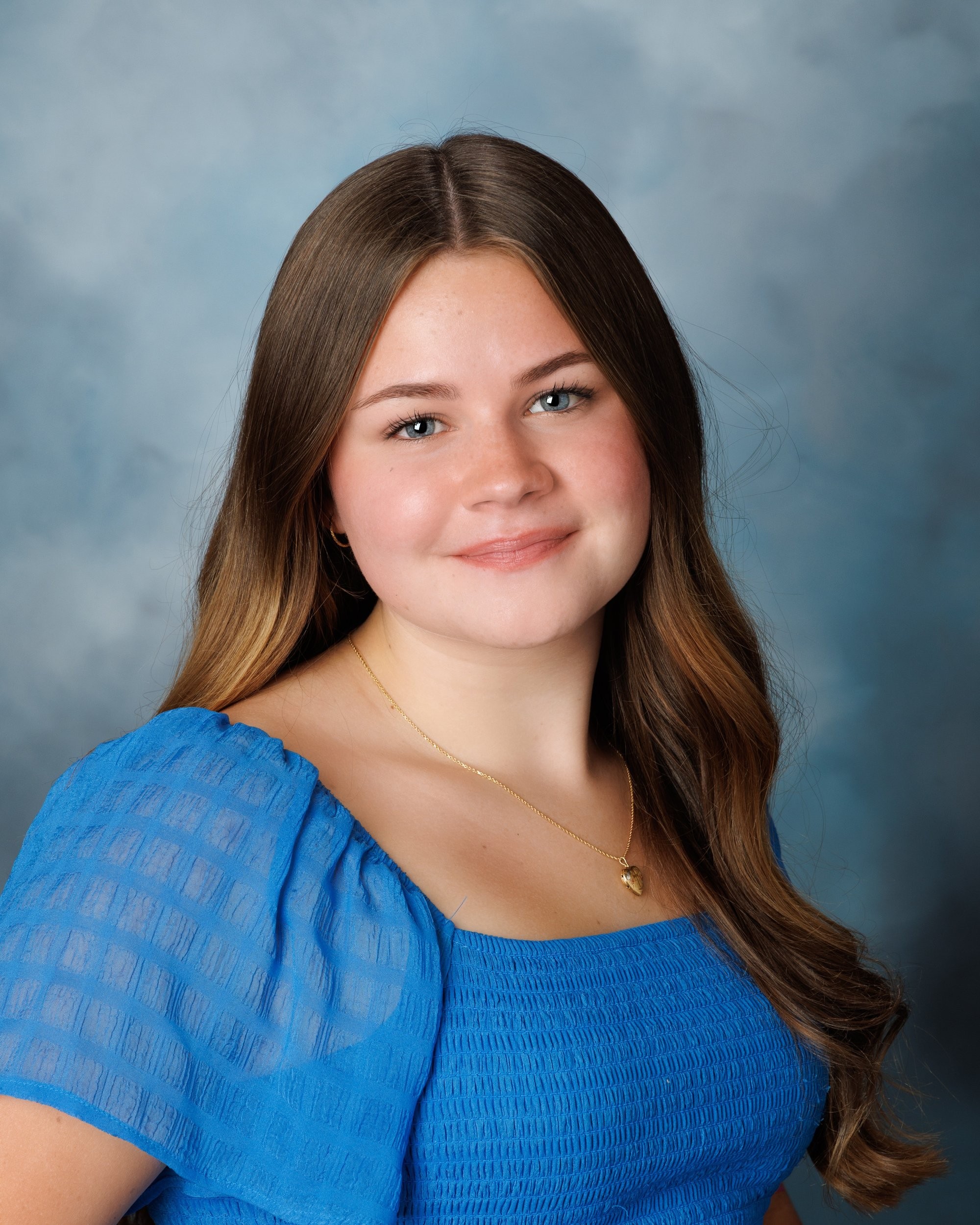 Natalie in blue dress and varsity jacket for Cabrini Senior Session photo shoot